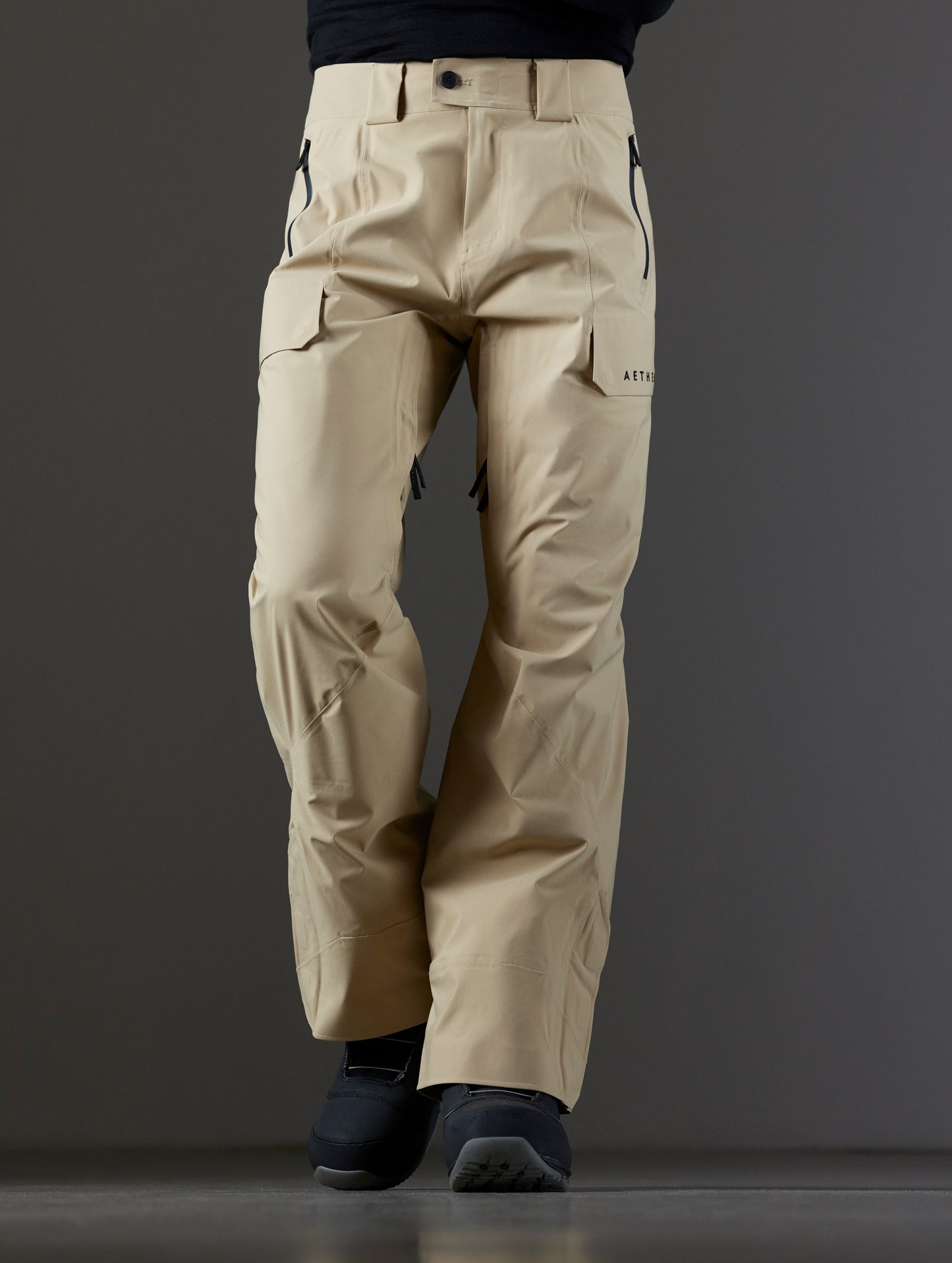 Front lower body view of man wearing Maverick Snow-Shell Pant in Desert Tan from AETHER Apparel.