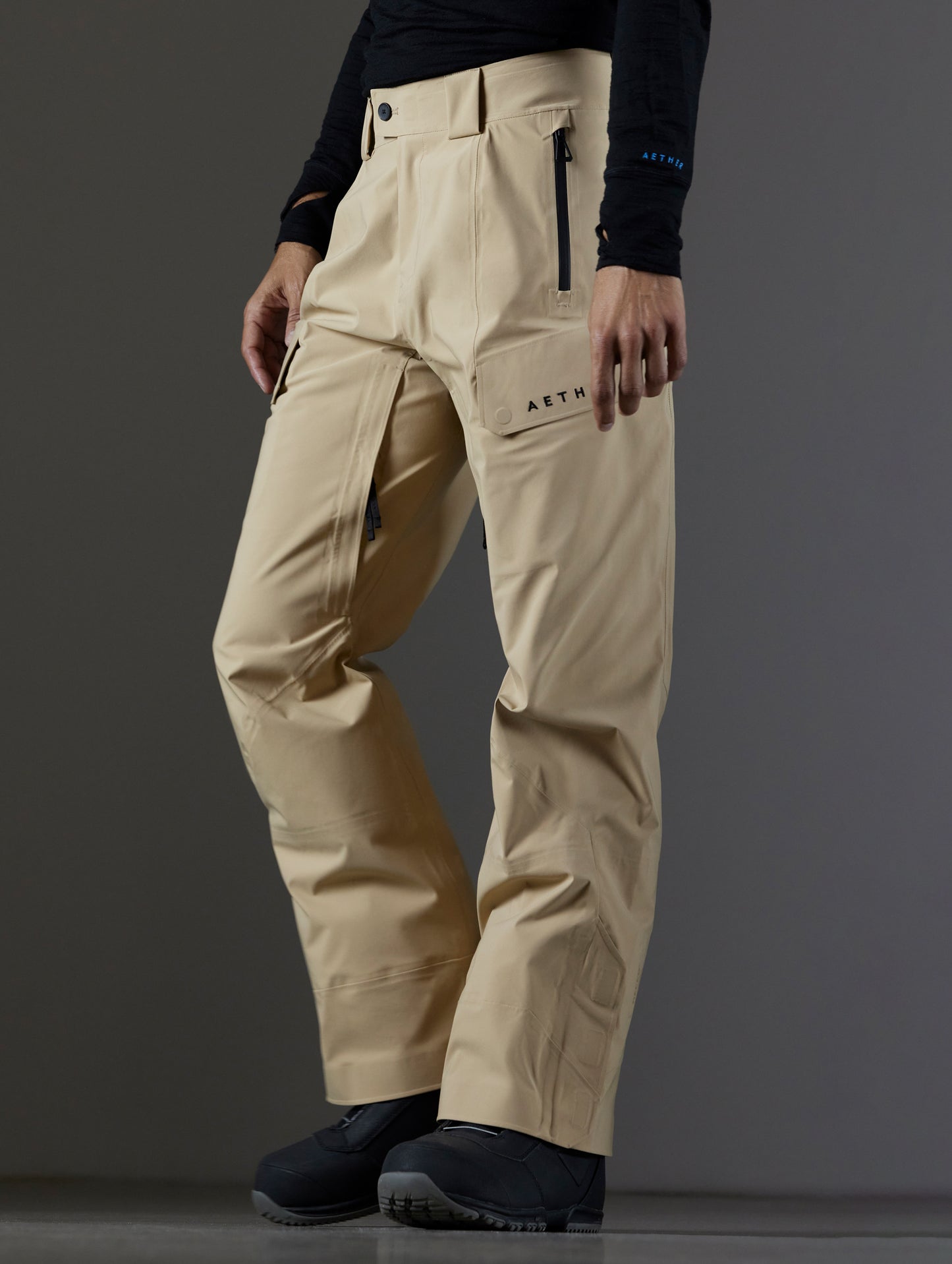 Front 3/4 lower body view of man wearing Maverick Snow-Shell Pant in Desert Tan from AETHER Apparel.