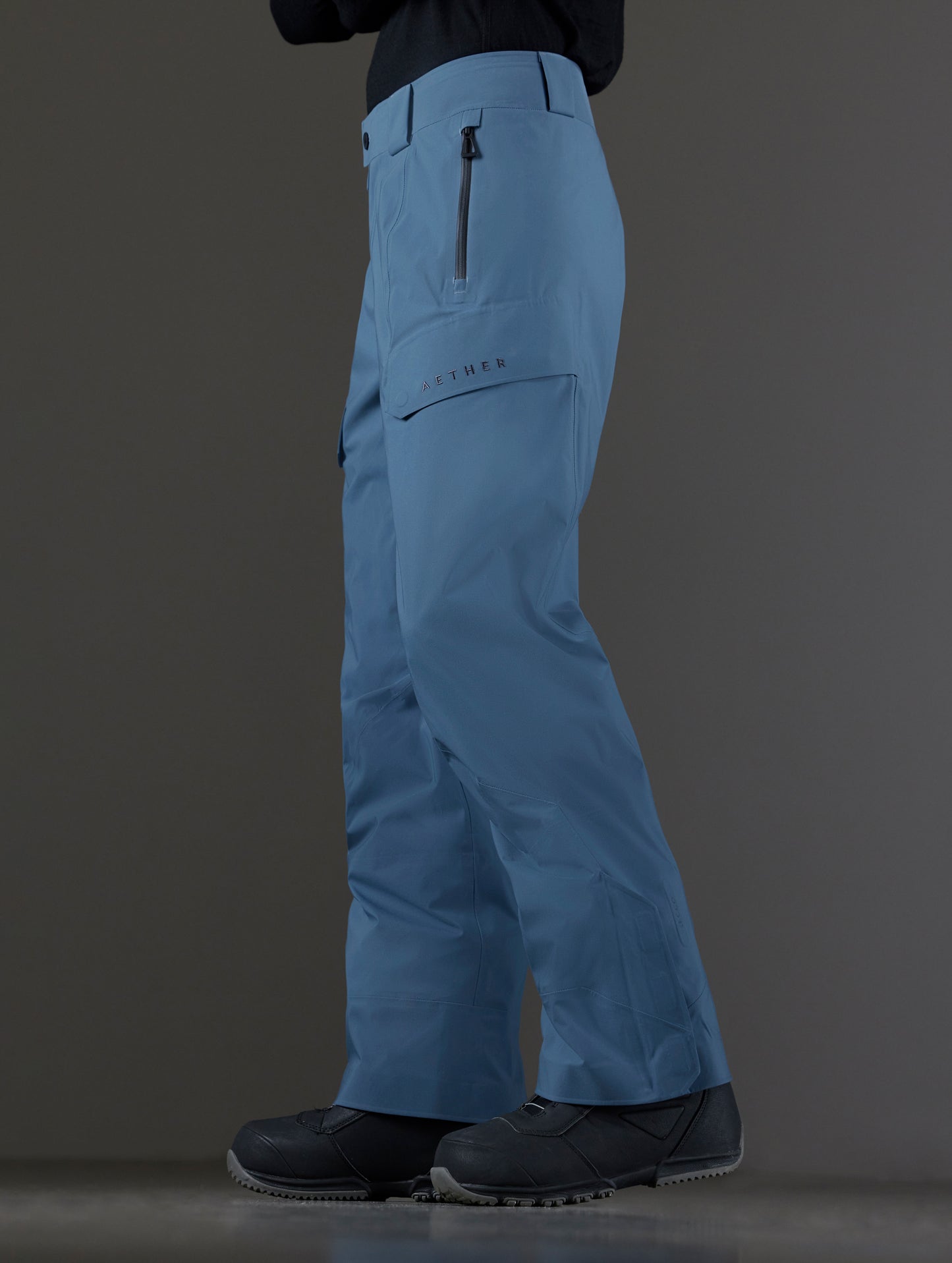 Side profile lower body view of man wearing Maverick Snow-Shell Pant in Portal Blue from AETHER Apparel.