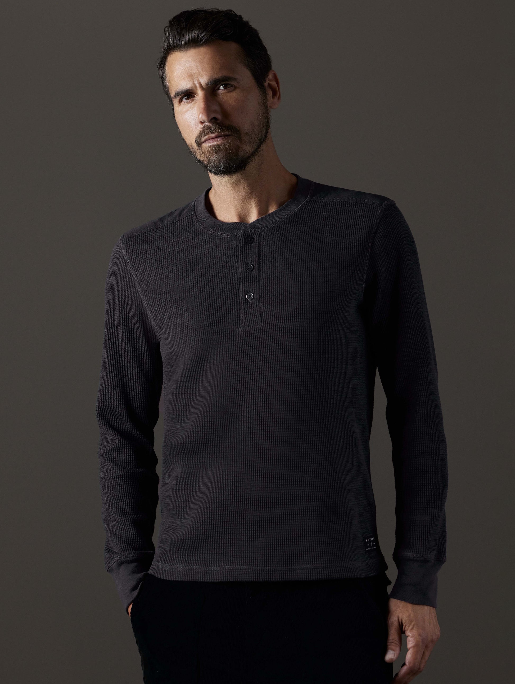 Front body view of man wearing Milford Waffle Henley in Onyx Black from AETHER Apparel.