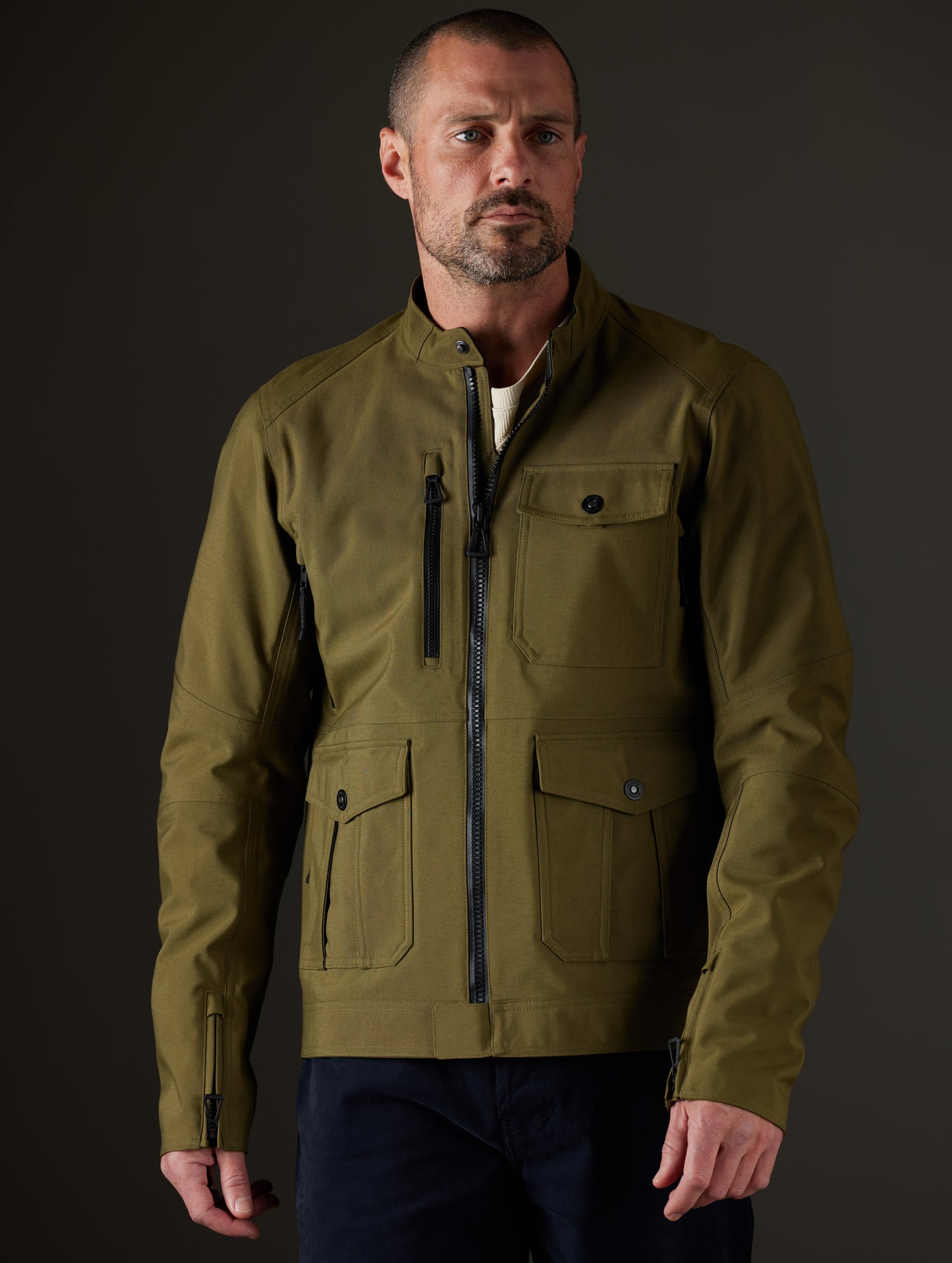 Front body view of man wearing Mulholland Motorcycle Jacket in Command Green from AETHER Apparel.
