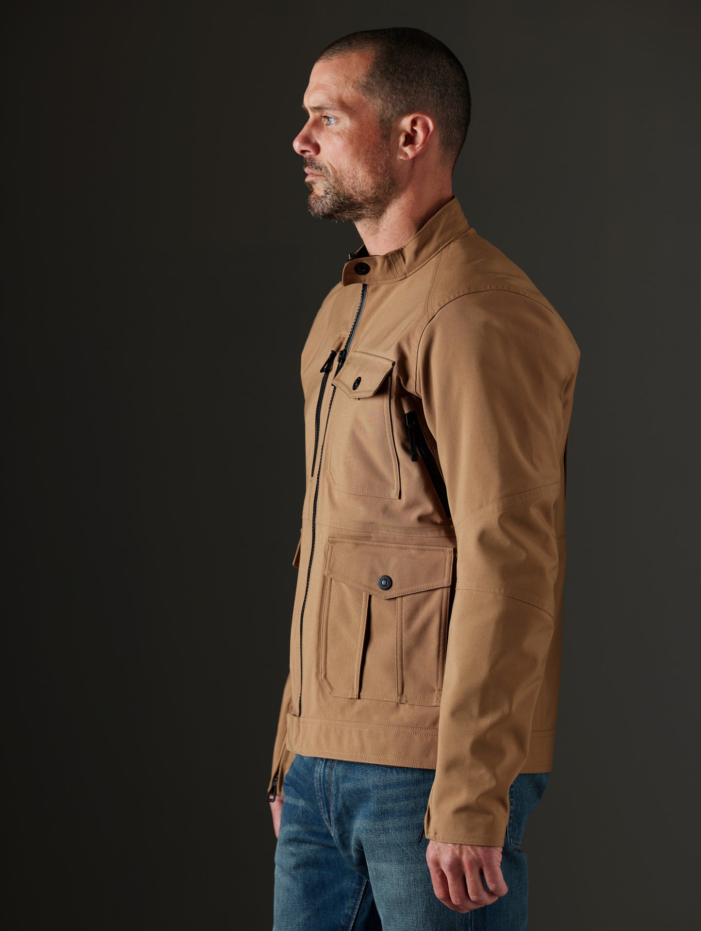 Side profile body view of man wearing Mulholland Motorcycle Jacket in Reverse Brown from AETHER Apparel.