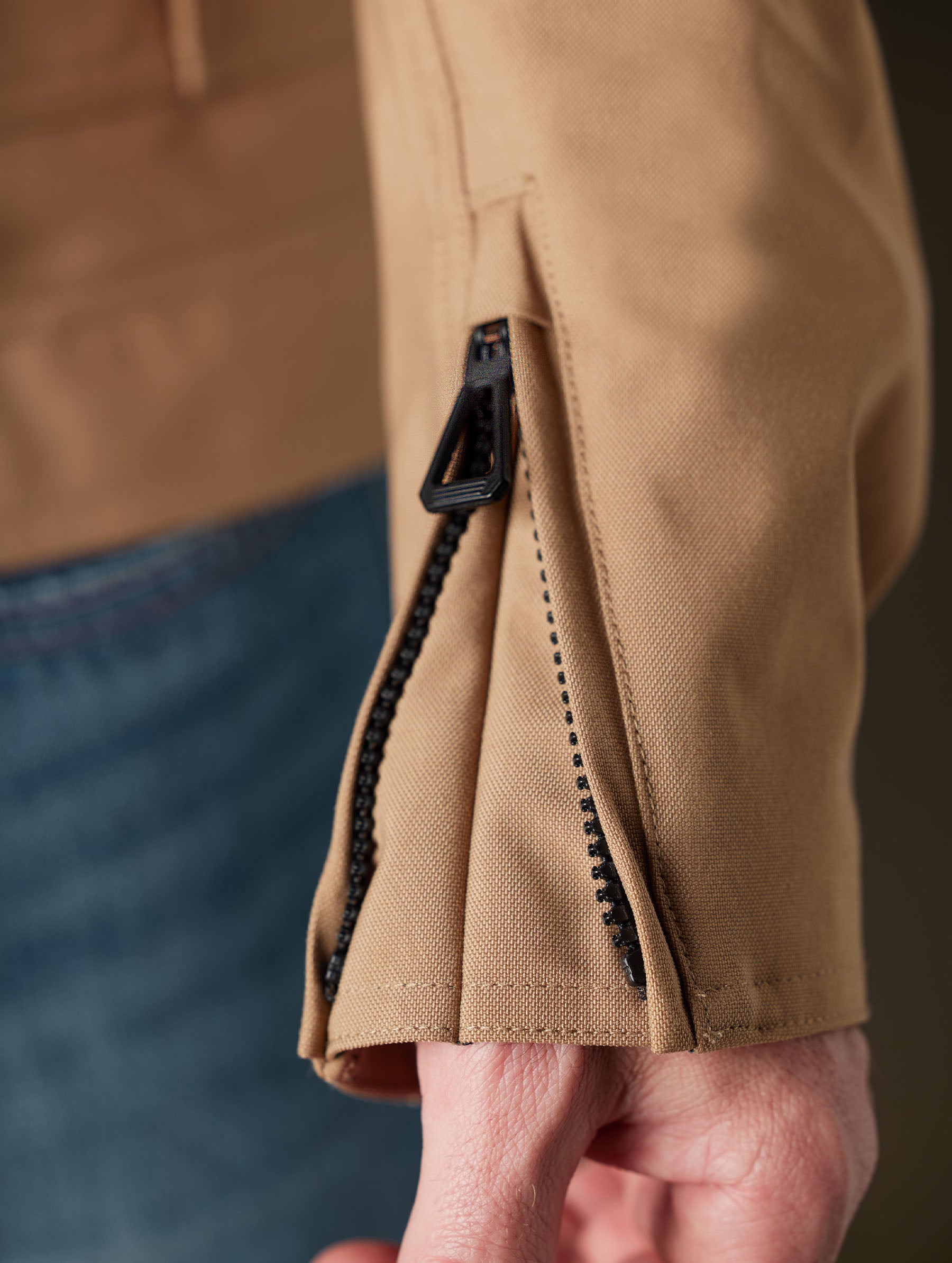 Closeup detailed view of the sleeve’s gusset and locking head zipper on the Mulholland Motorcycle Jacket in Reserve Brown from AETHER Apparel.