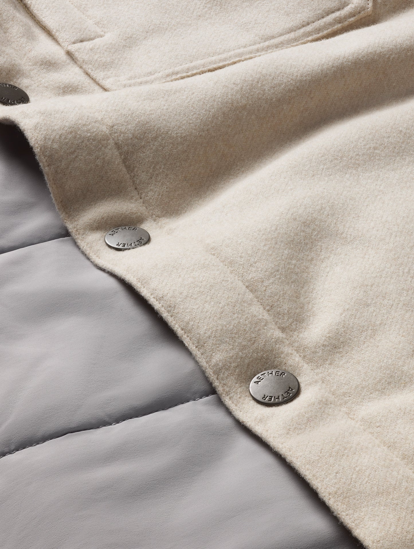 Closeup detailed view of buttons on Nova Insulated Button-Down in Bone Heather white from AETHER Apparel.