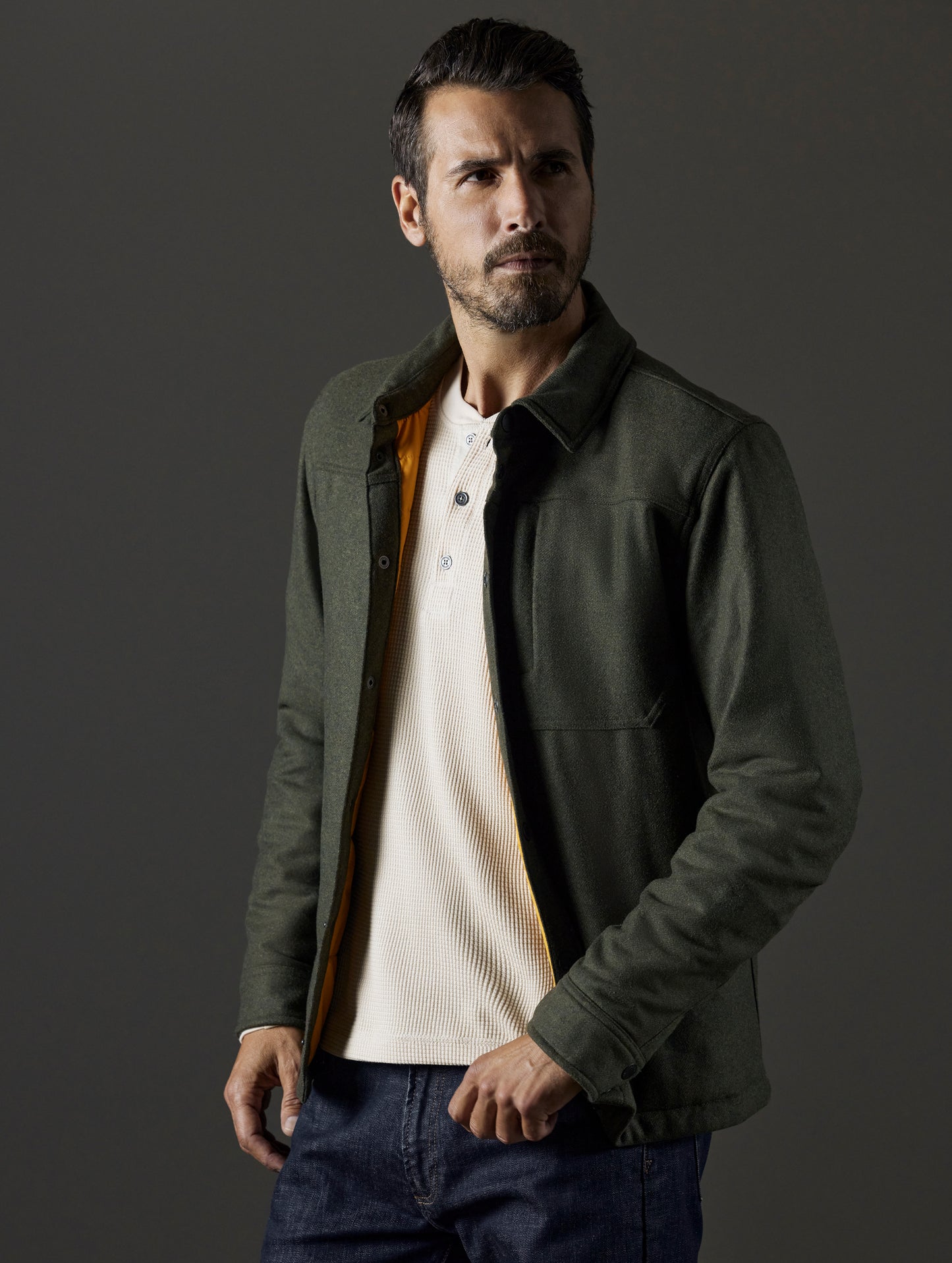 Front 3/4 body view of man wearing unbuttoned Nova Insulated Button-Down in Command Green from AETHER Apparel.