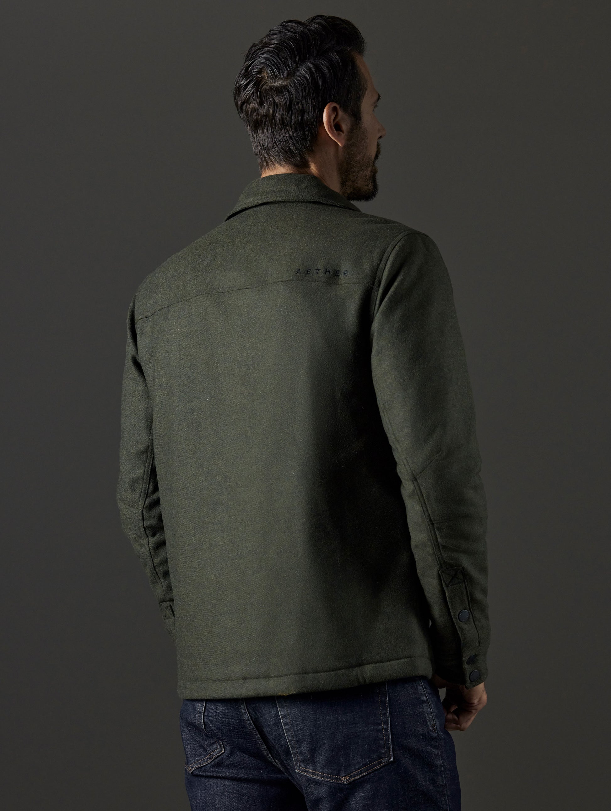 Rear 3/4 body view of man wearing Nova Insulated Button-Down in Command Green from AETHER Apparel.