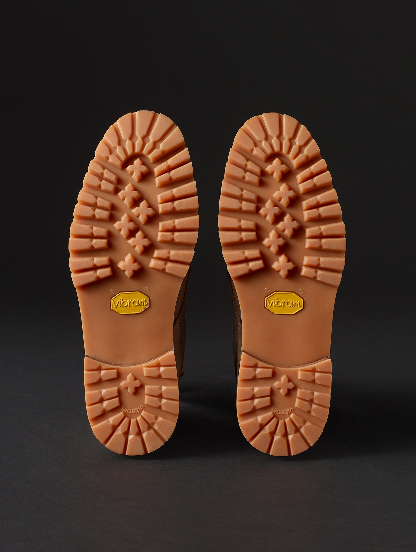 View of bottoms of Vibram outsoles on Ojai City Boot in Bison Brown suede and canvas from AETHER Apparel.