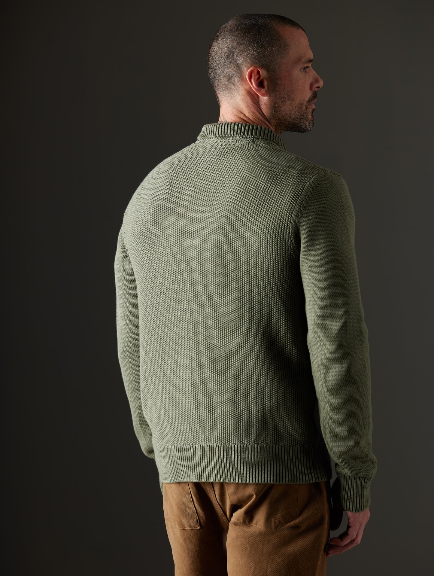 Rear 3/4 body view of man wearing Oliver Cotton Button-Up Sweater in Fern Green from AETHER Apparel.