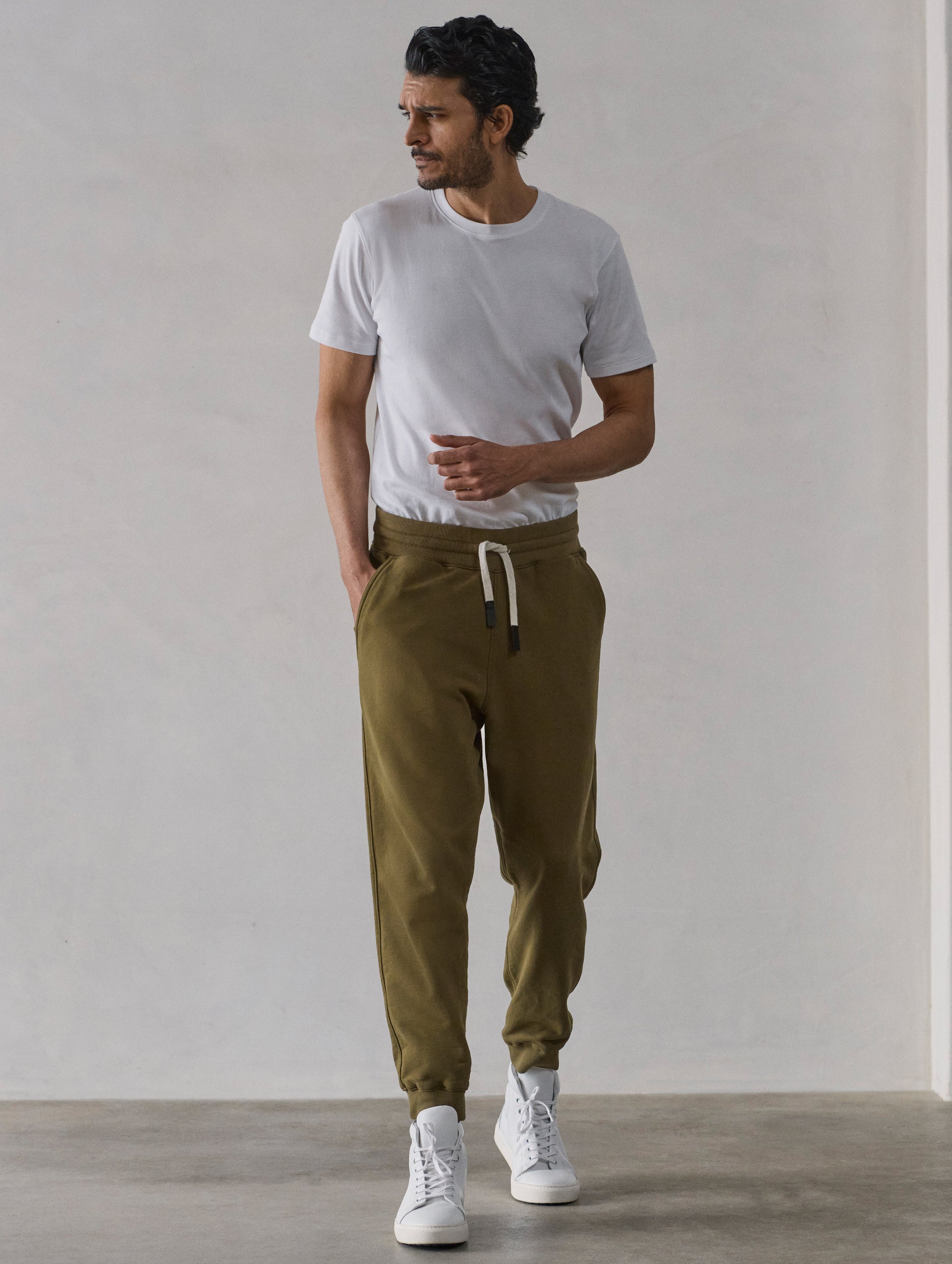 Front full-body view of man wearing Osa Cuffed Sweatpant in Command Green from AETHER Apparel.