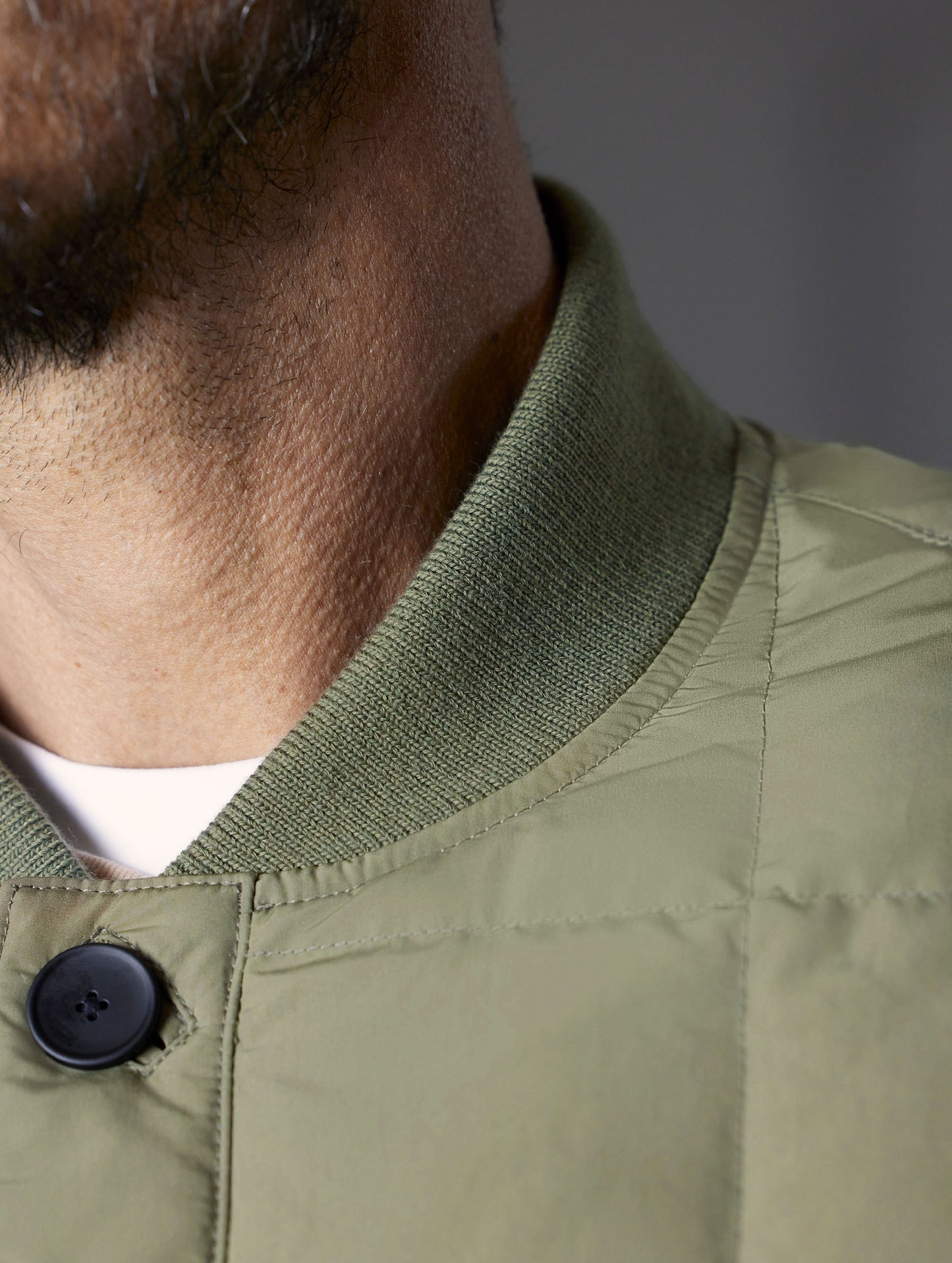 Closeup detailed view of the collar and top button of the Pacer Jacket in Fern Green from AETHER Apparel.