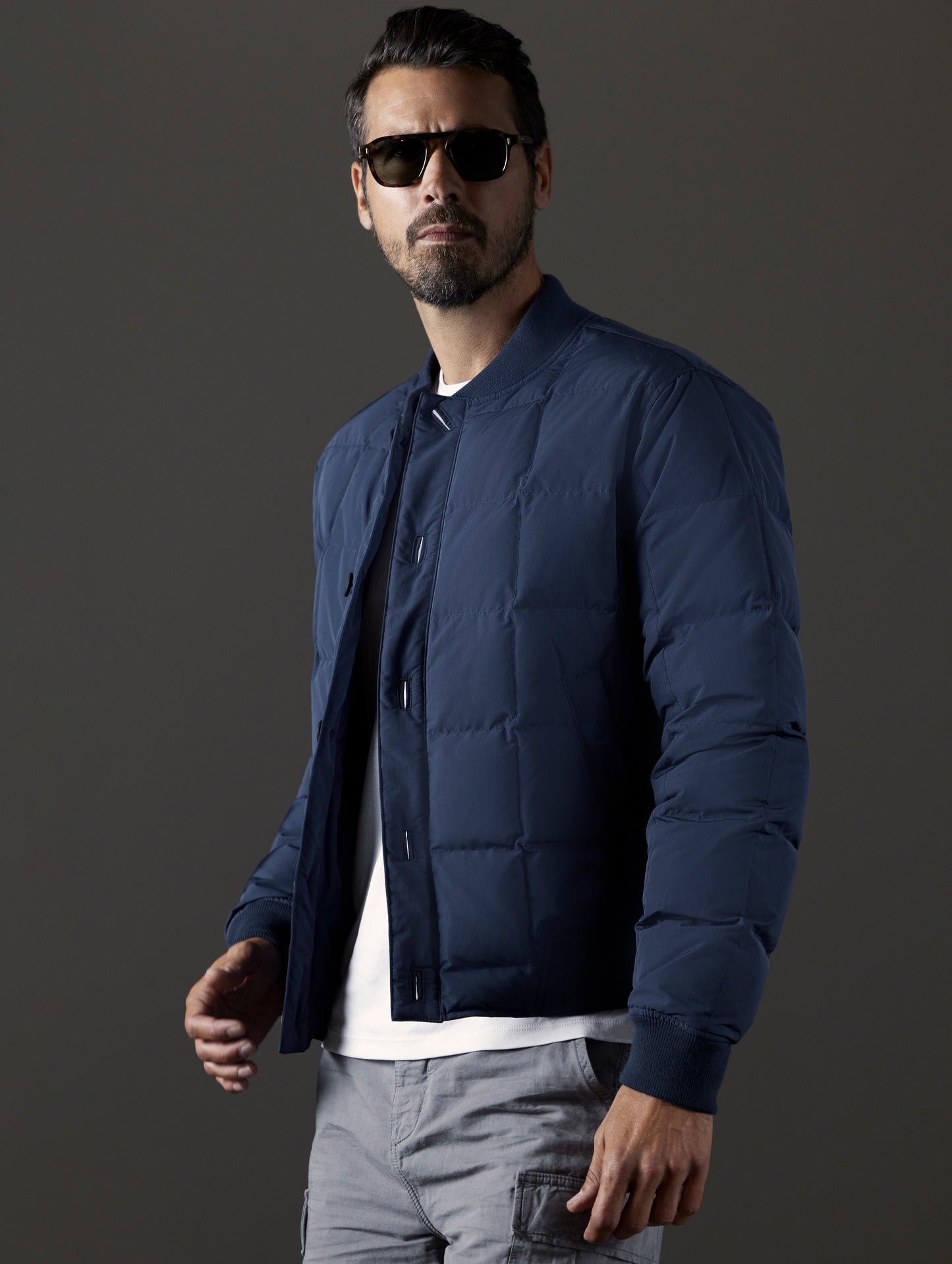 Front 3/4 body view of man wearing Pacer Jacket in Total Eclipse blue from AETHER Apparel.
