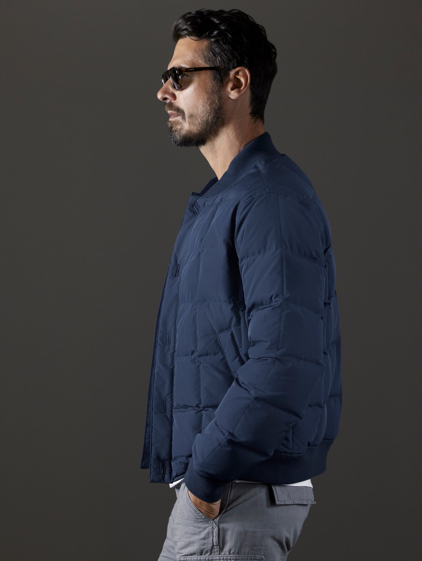 Side profile body view of man wearing Pacer Jacket in Total Eclipse blue from AETHER Apparel.