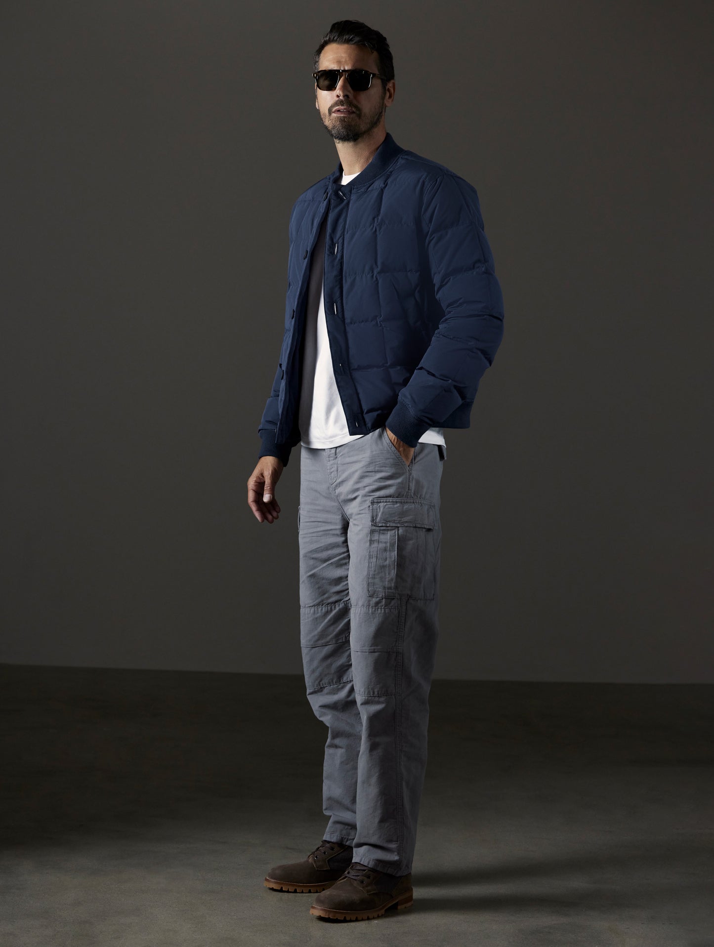 Front 3/4 full-body view of man wearing Pacer Jacket in Total Eclipse blue from AETHER Apparel.