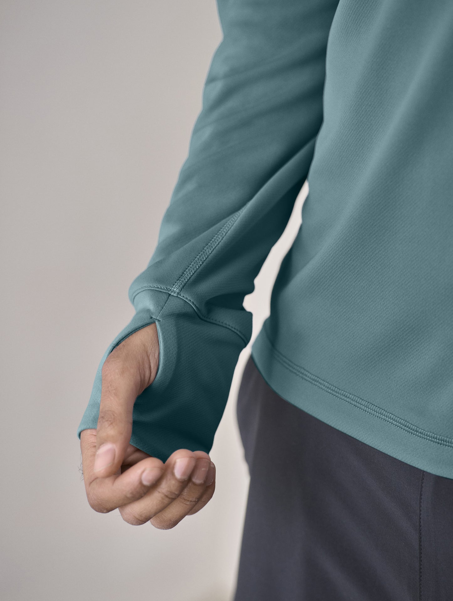 Closeup detailed view of wrist-cuff thumb-hole on sleeve of the Pacific Hooded Sun Shirt in Aqua Blue from AETHER Apparel.