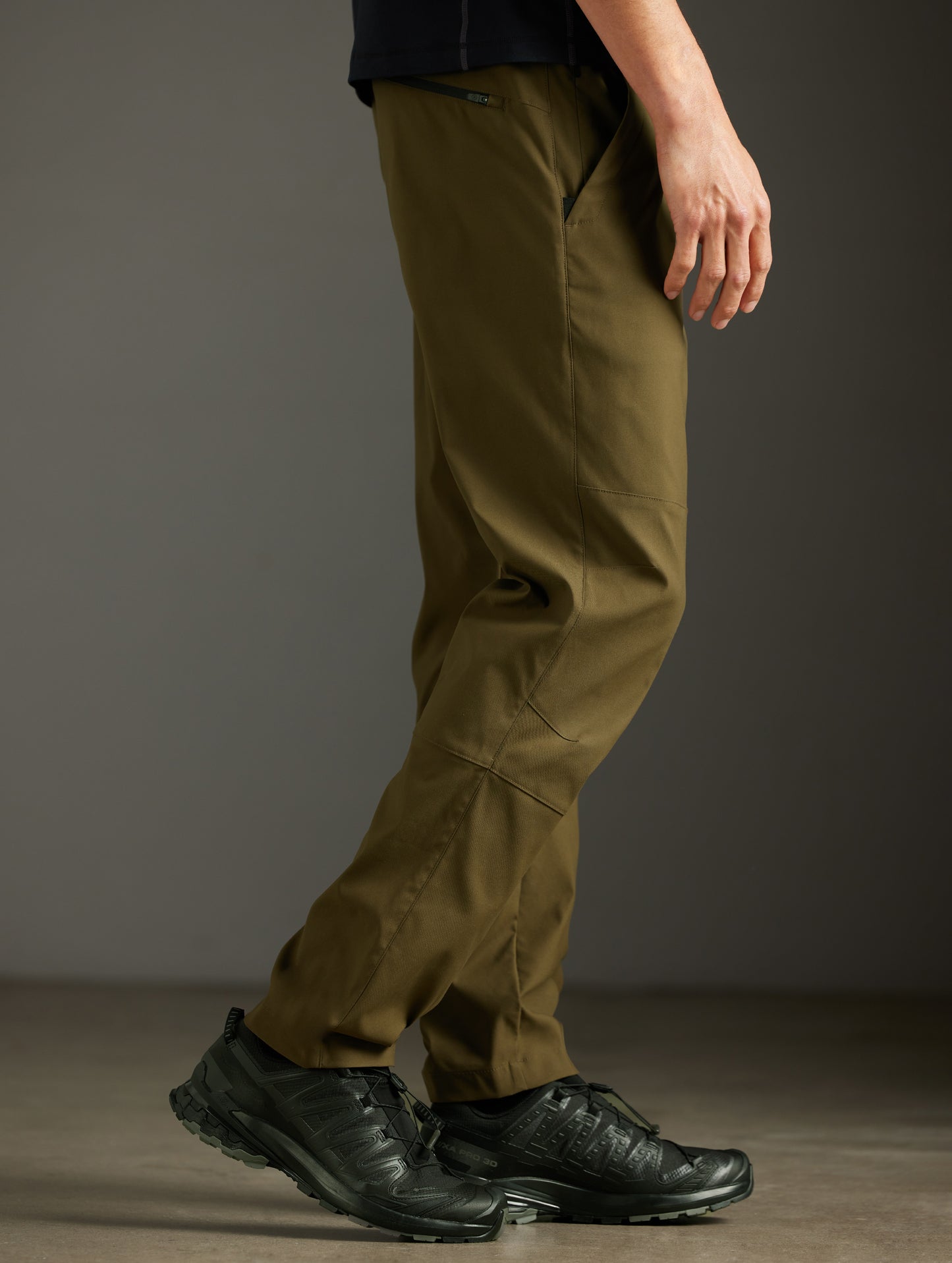 Side profile lower body view of man wearing Perth Pant in Cadet Green from AETHER Apparel.