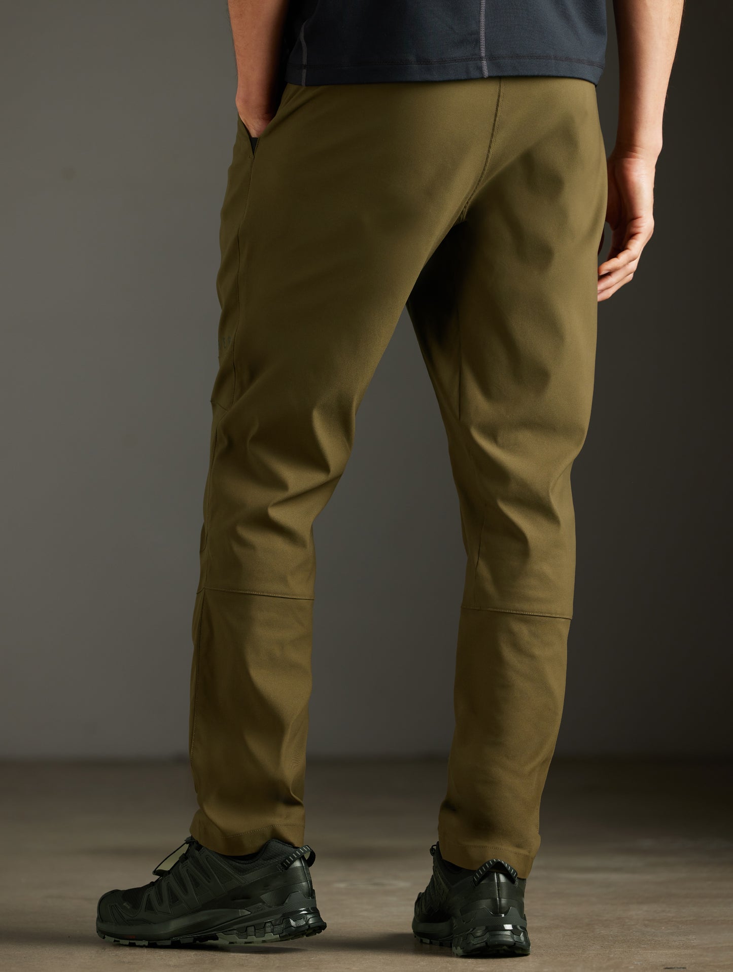 Rear 3/4 lower body view of man wearing Perth Pant in Cadet Green from AETHER Apparel.