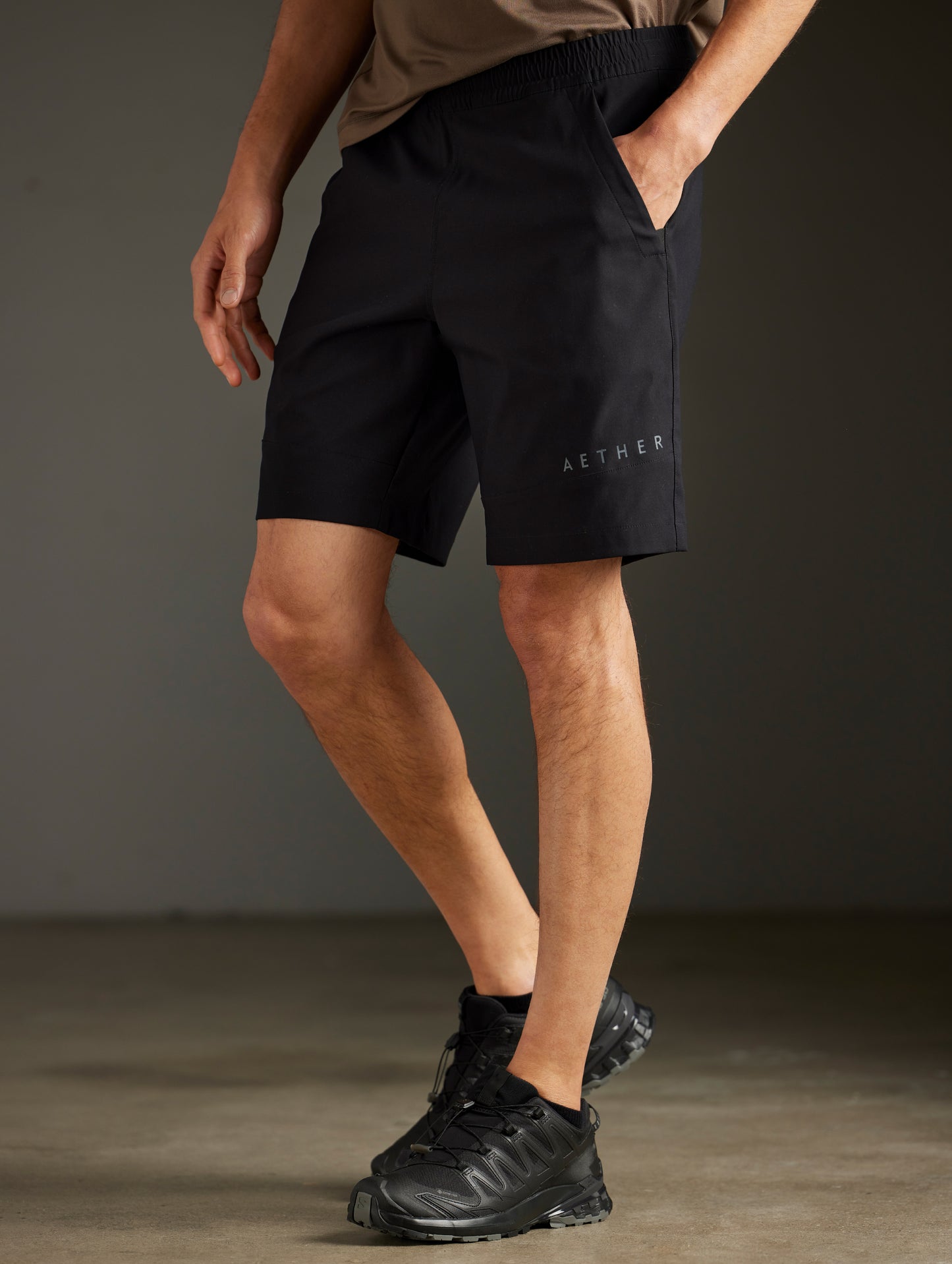 Front 3/4 lower body view of man wearing Perth Short in Onyx Black from AETHER Apparel.