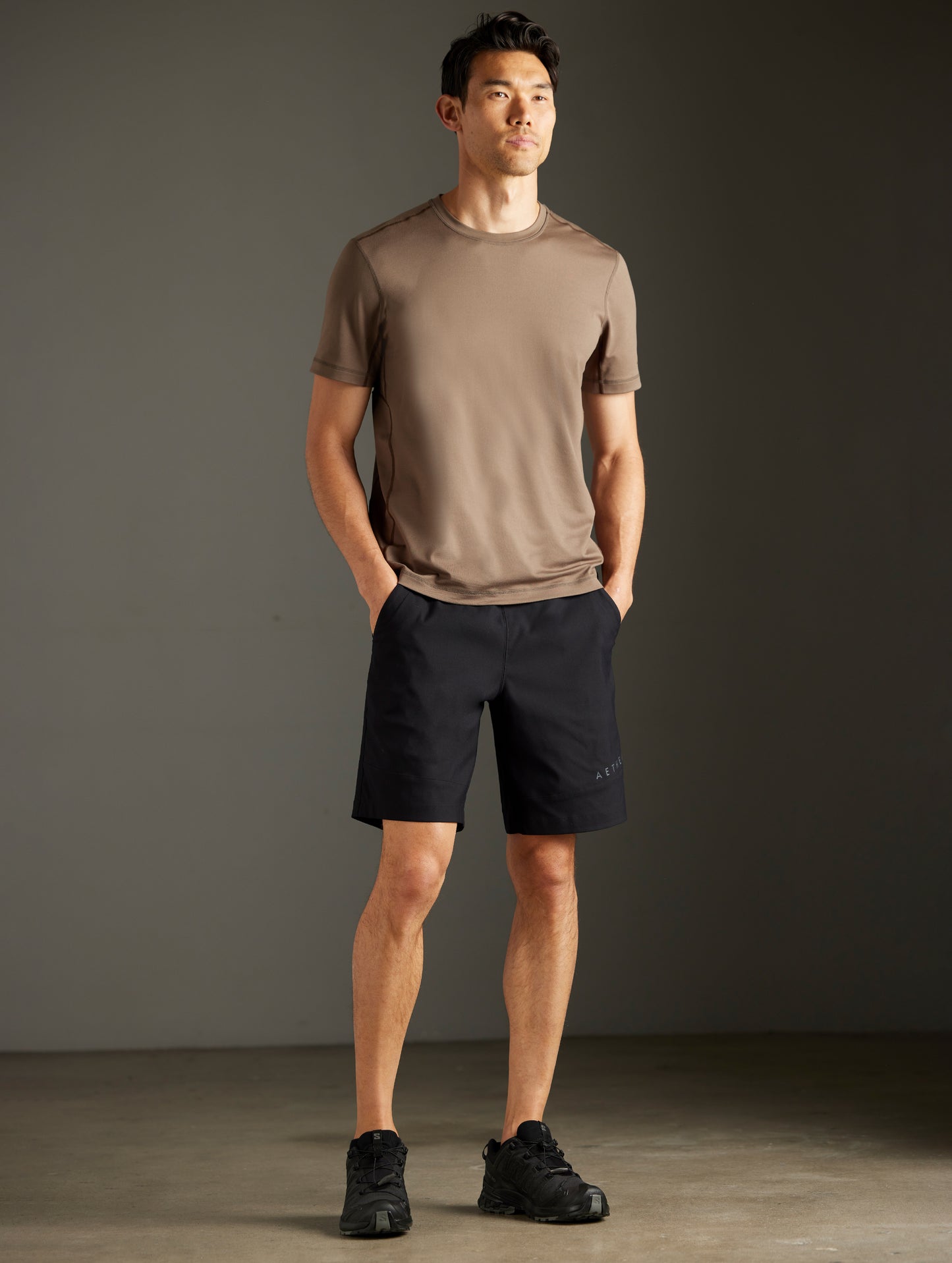 Front 3/4 full-body view of man wearing Perth Short in Onyx Black from AETHER Apparel.