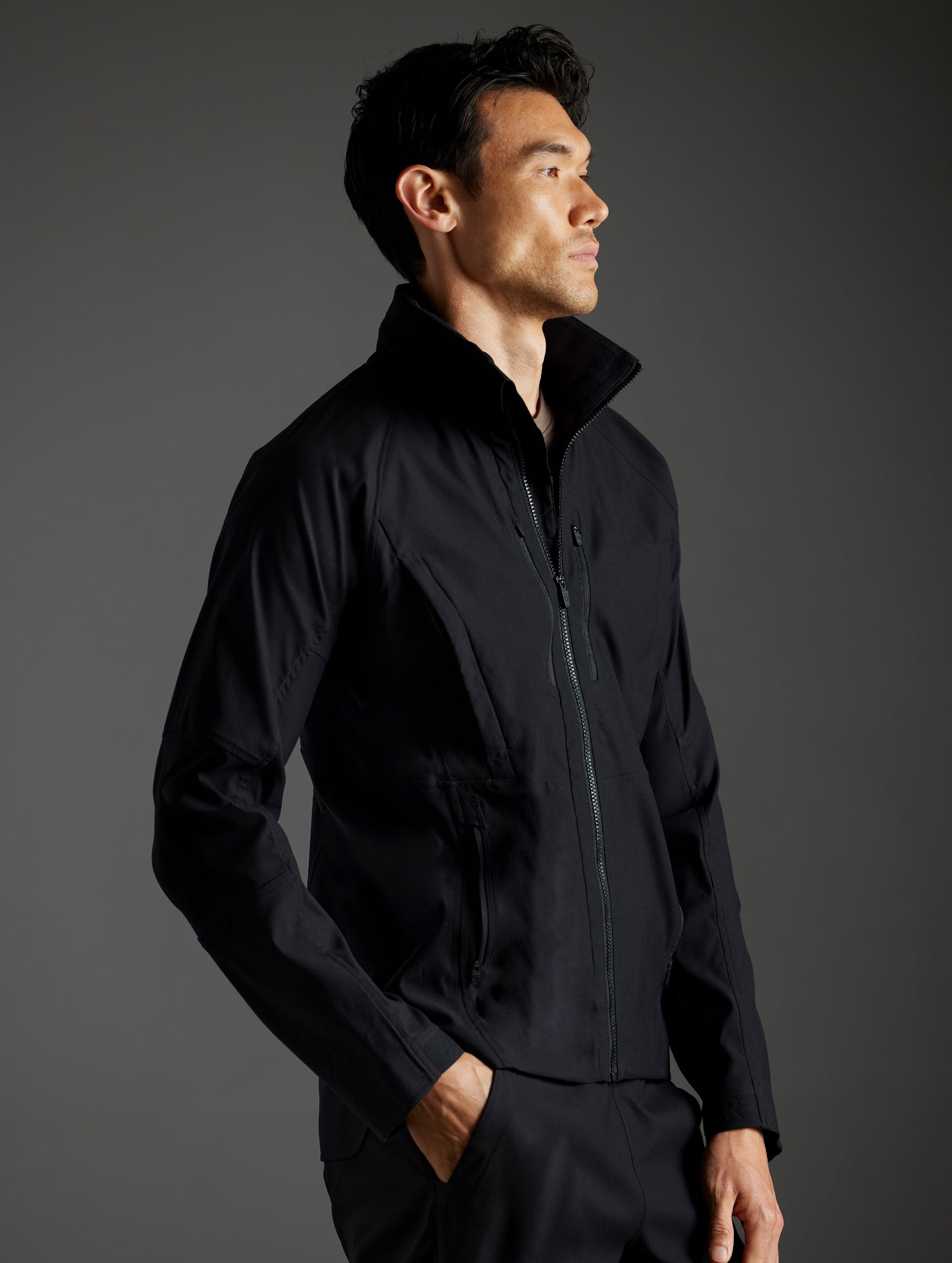Side profile body view of man wearing Perth Vented Jacket in Onyx Black from AETHER Apparel.