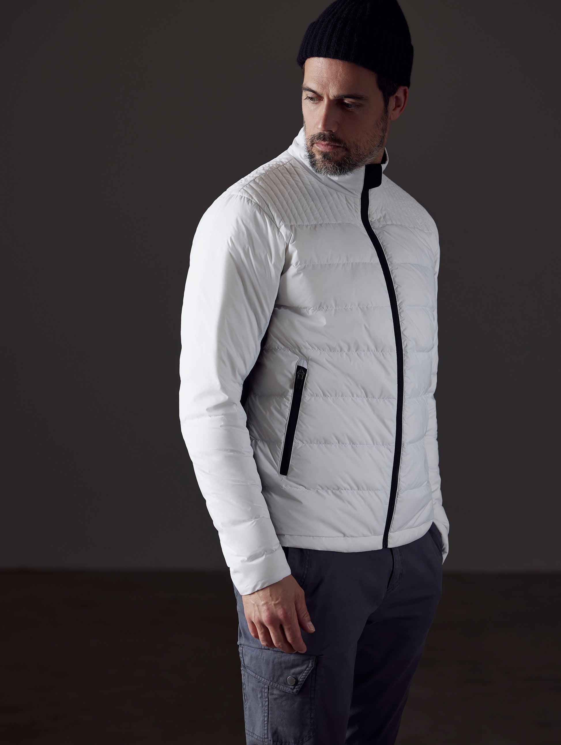 Front 3/4 body view of man looking over shoulder wearing Phantom Jacket in White from AETHER Apparel.