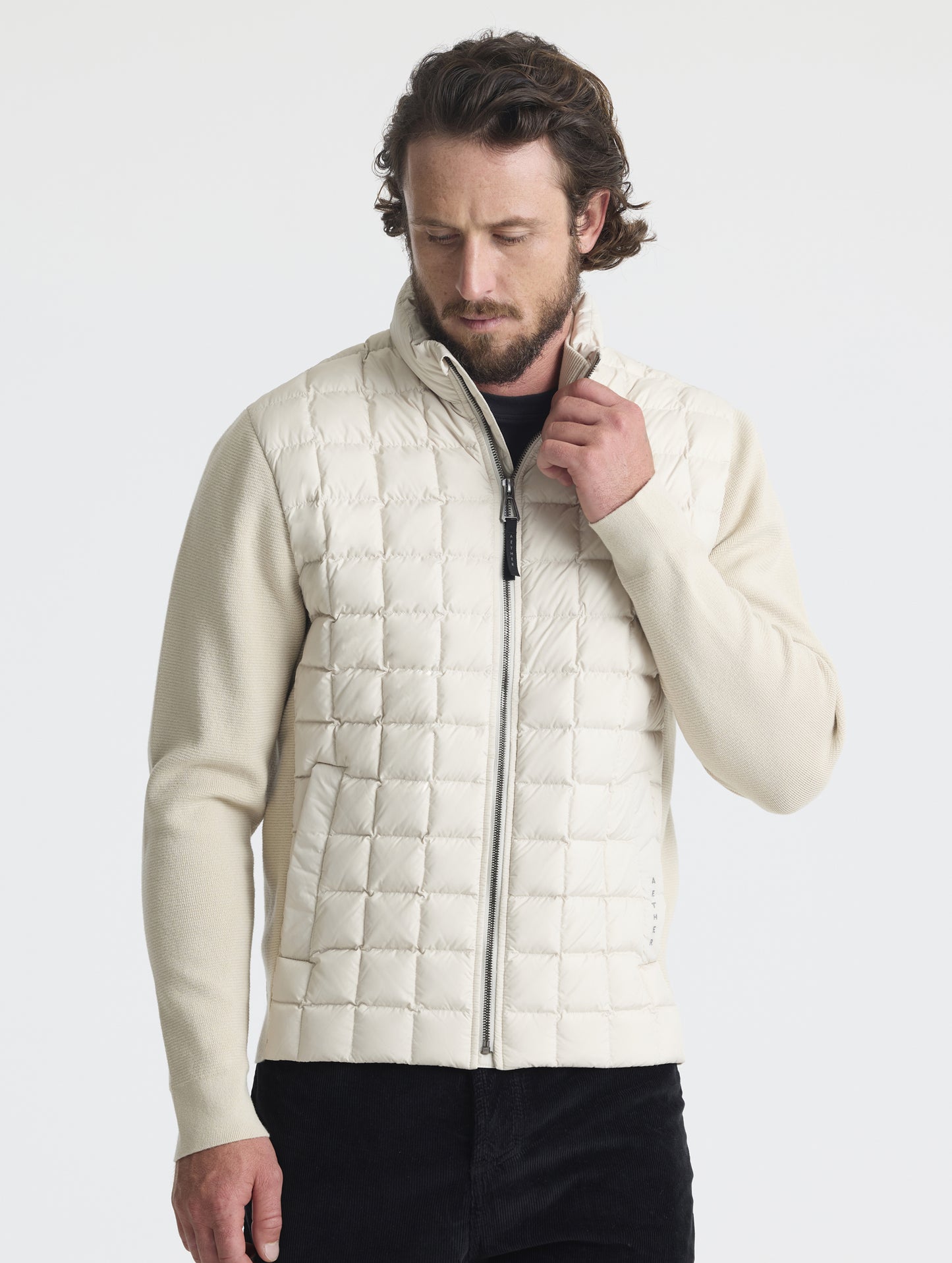 Front upper-body view of man wearing zipped-up M Phase Full-Zip in Bone white from AETHER Apparel.