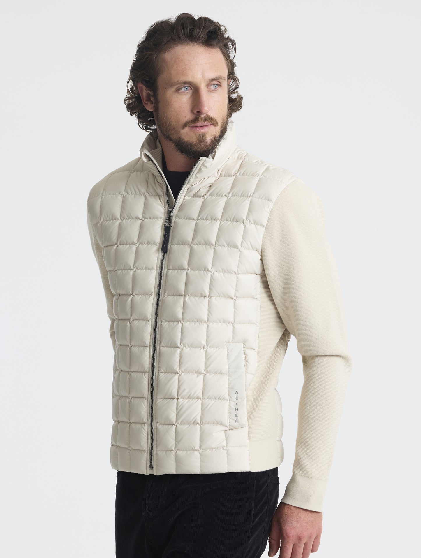 Front, angled upper-body view of man wearing M Phase Full-Zip in Bone white from AETHER Apparel.