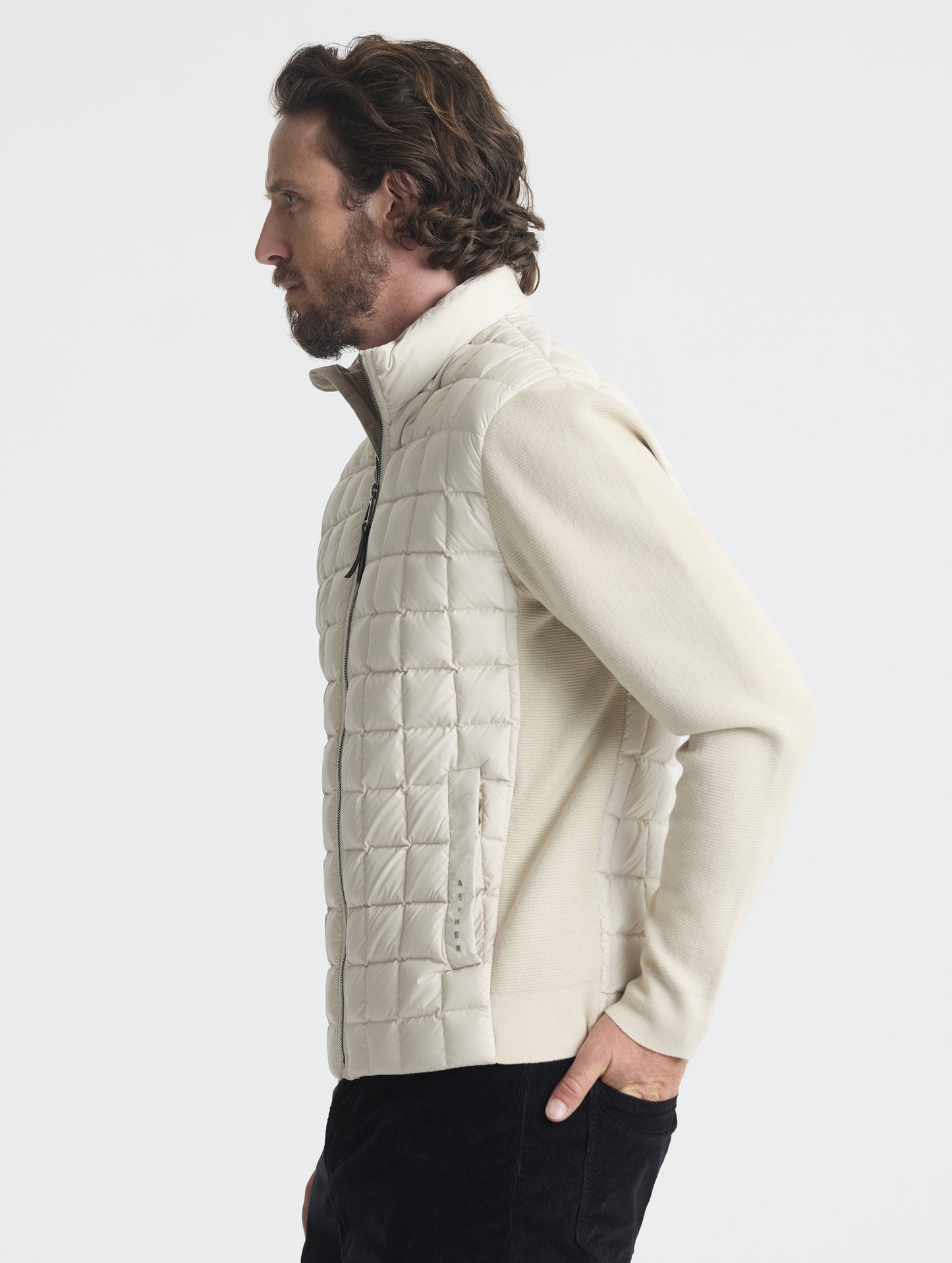 Side profile upper-body view of man wearing M Phase Full-Zip in Bone white from AETHER Apparel.