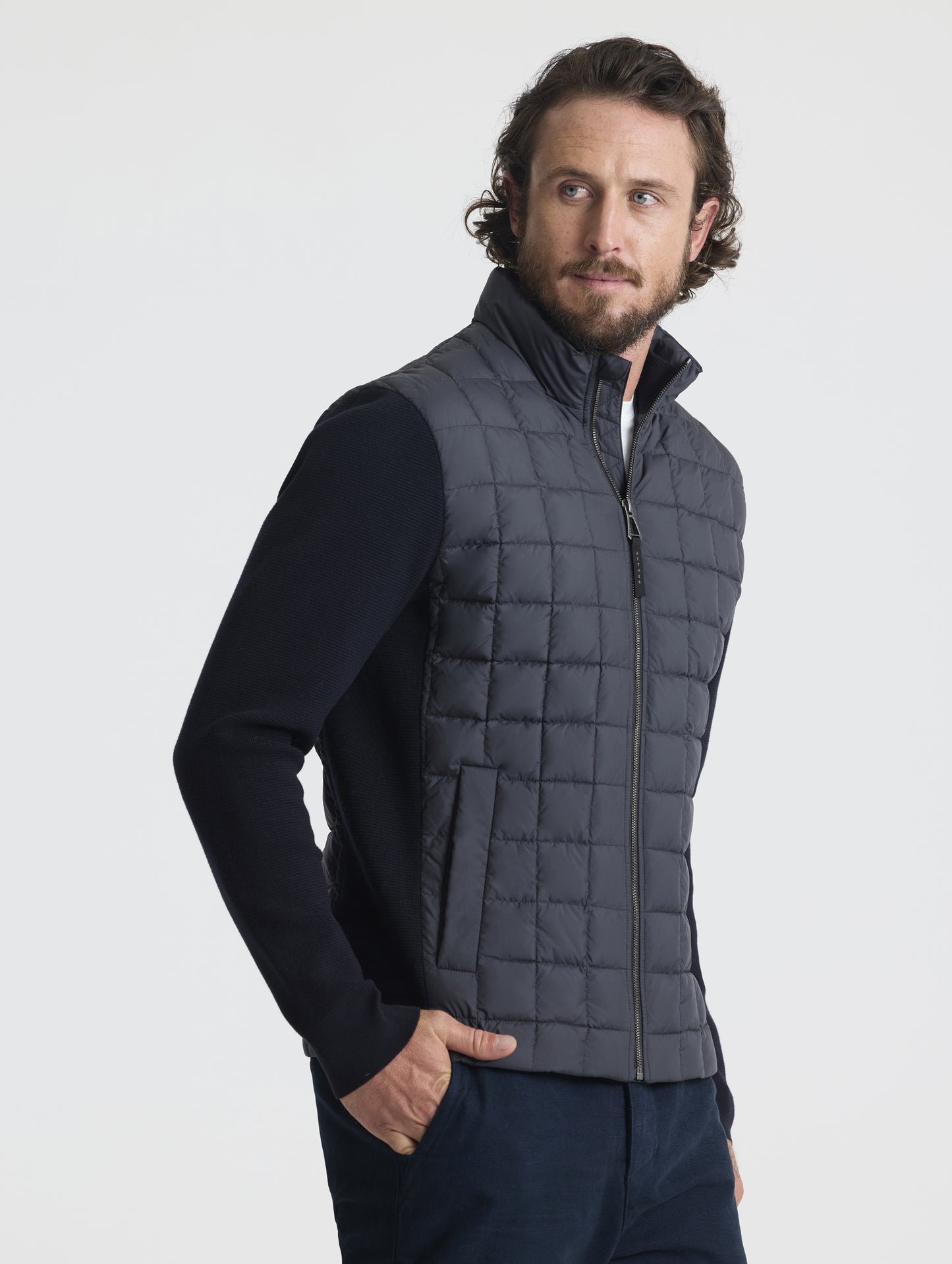 Front, angled, upper-body view of man wearing M Phase Full-Zip in Onyx Black from AETHER Apparel.
