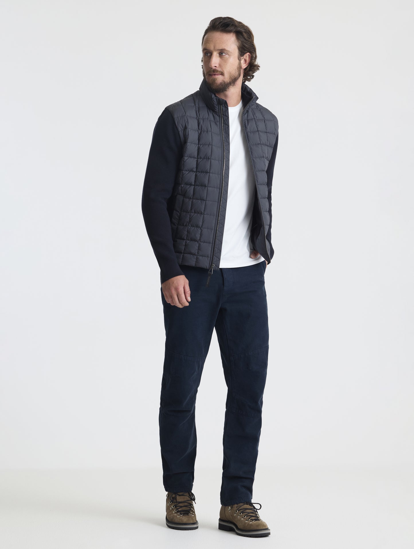 Front, angled full-body view of man wearing unzipped M Phase Full-Zip in Onyx Black from AETHER Apparel.
