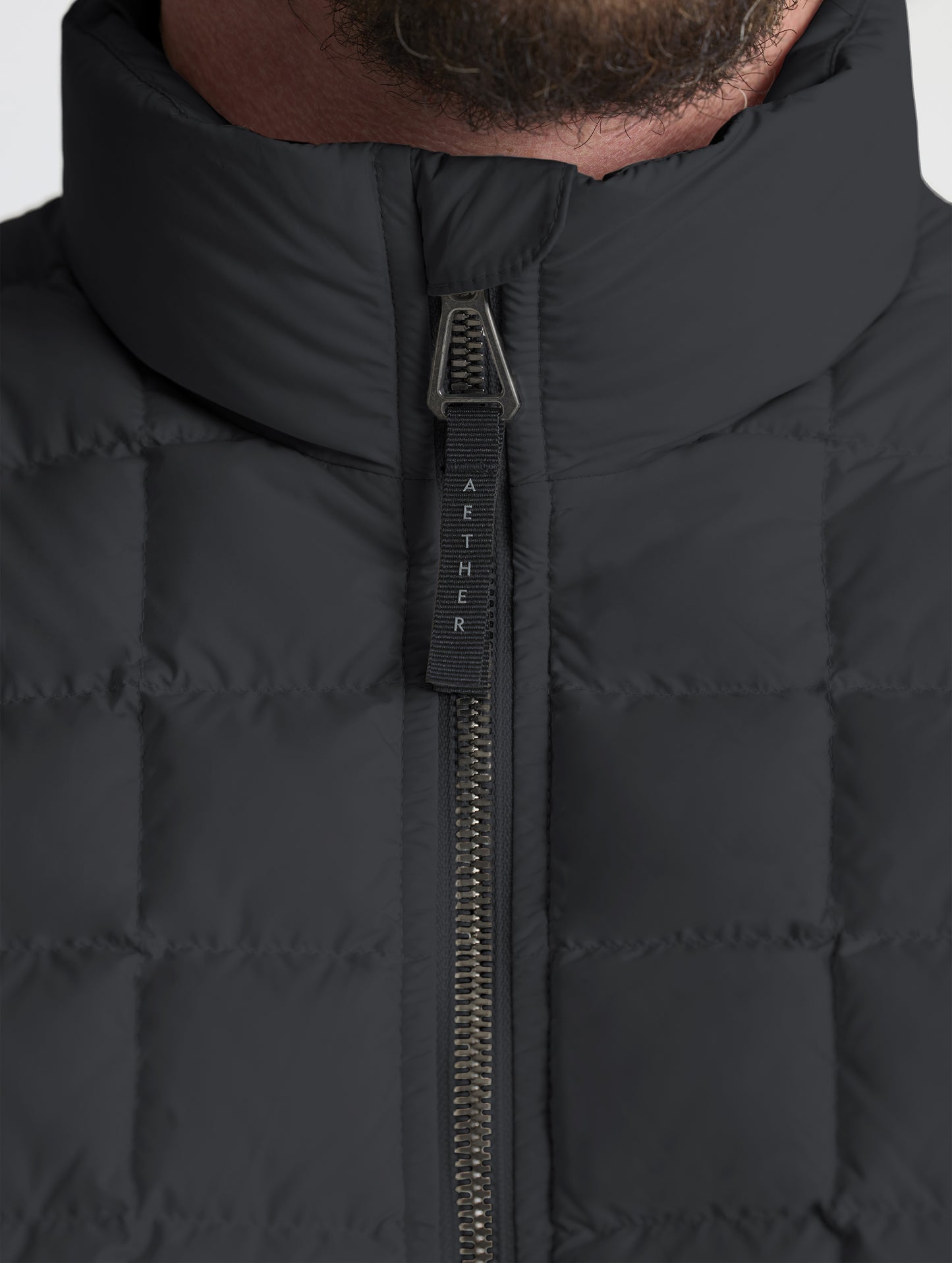 Closeup detailed view of the main center-front zipper on the M Phase Full-Zip in Onyx Black from AETHER Apparel.