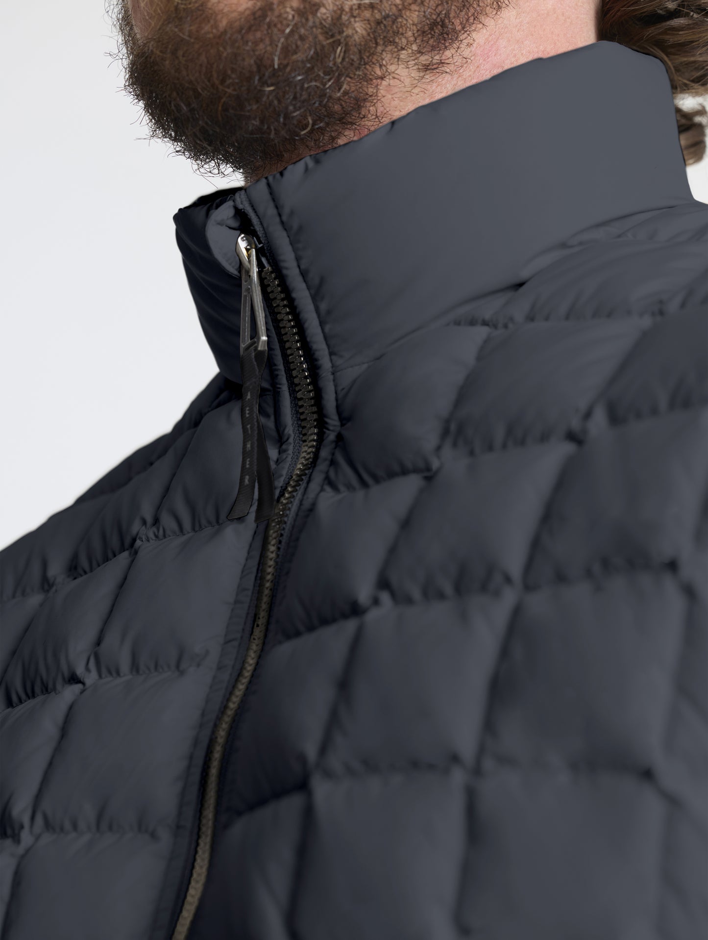 Closeup detailed view of the quilted body and insulated collar on the M Phase Full-Zip in Onyx Black from AETHER Apparel.