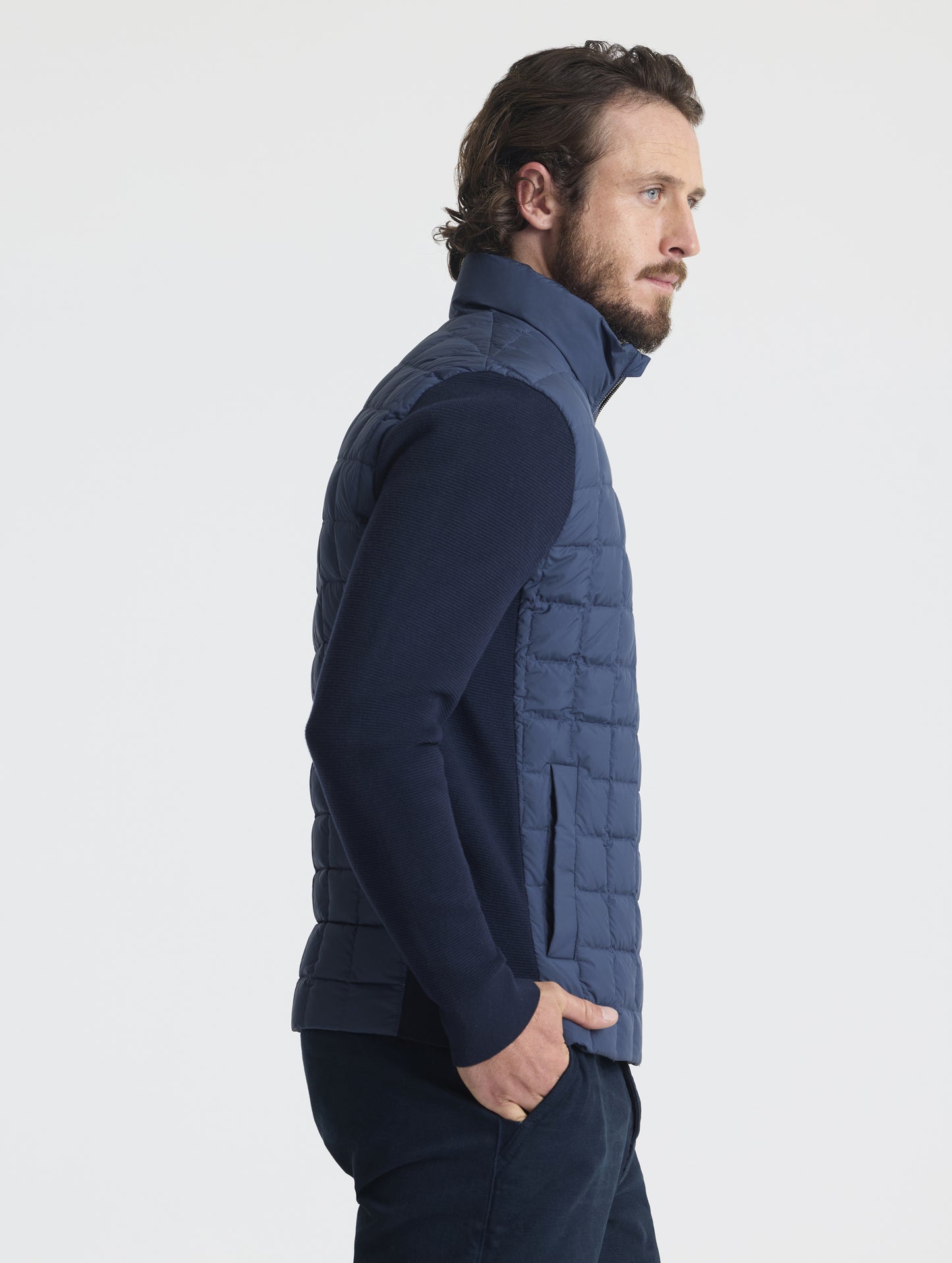 Side, profile upper-body view of man wearing M Phase Full-Zip in Total Eclipse dark blue from AETHER Apparel.