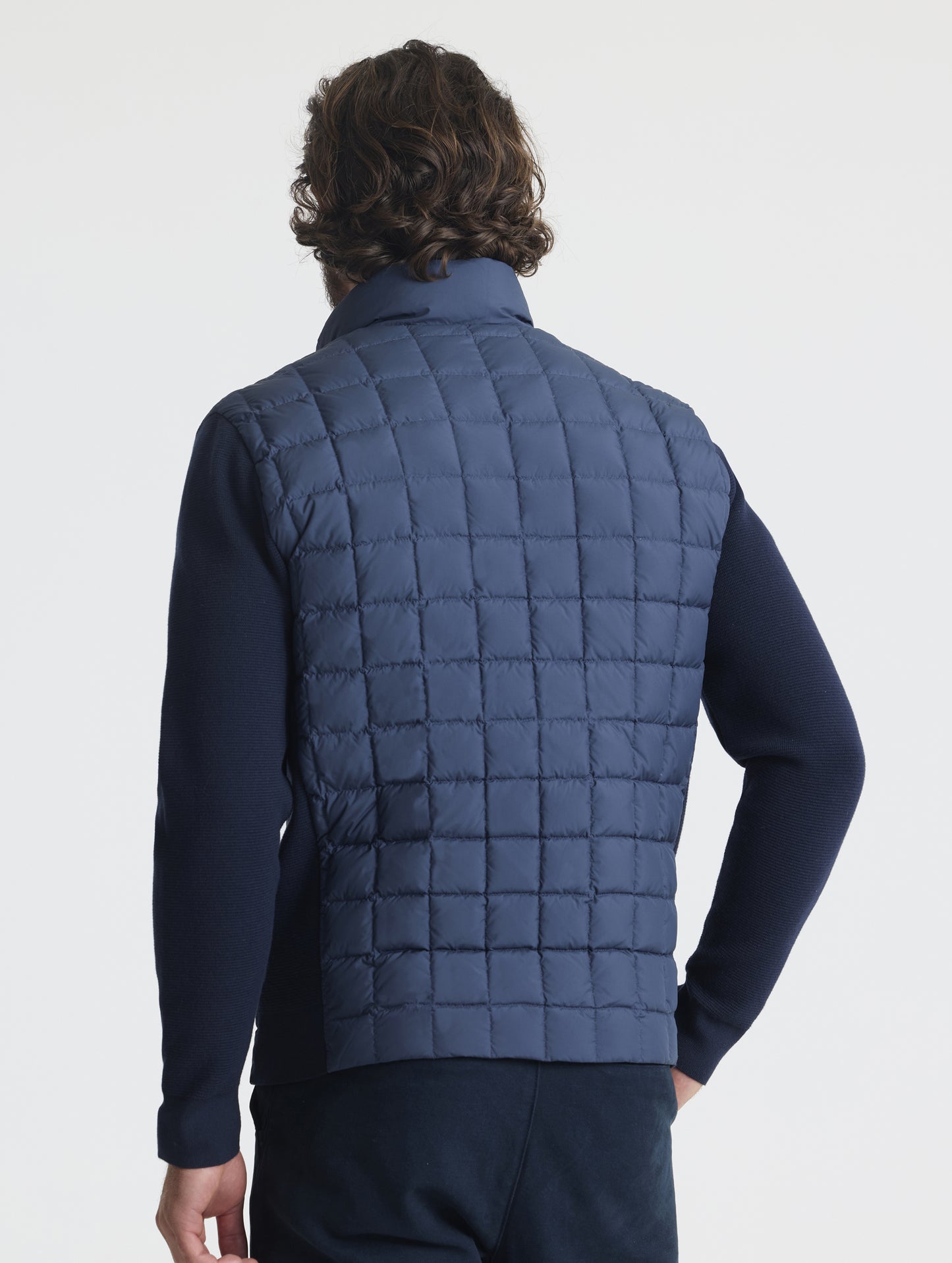 Rear, angled upper-body view of man wearing M Phase Full-Zip in Total Eclipse dark blue from AETHER Apparel.