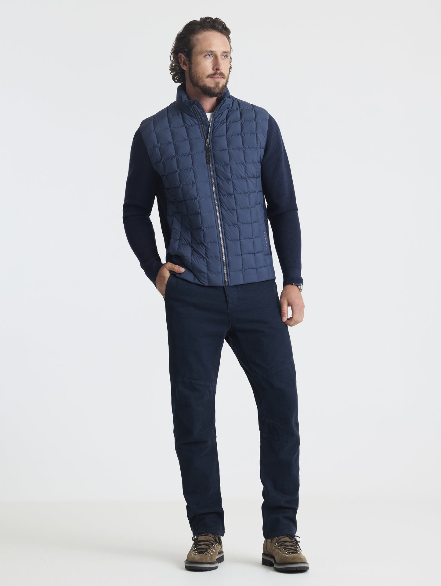 Front full-body view of man wearing zipped-up M Phase Full-Zip in Total Eclipse dark blue from AETHER Apparel.