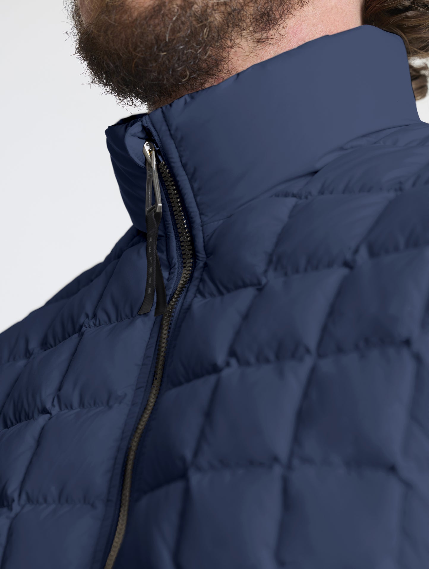 Closeup detailed view of the quilted body and insulated collar on the M Phase Full-Zip in Total Eclipse dark blue from AETHER Apparel.