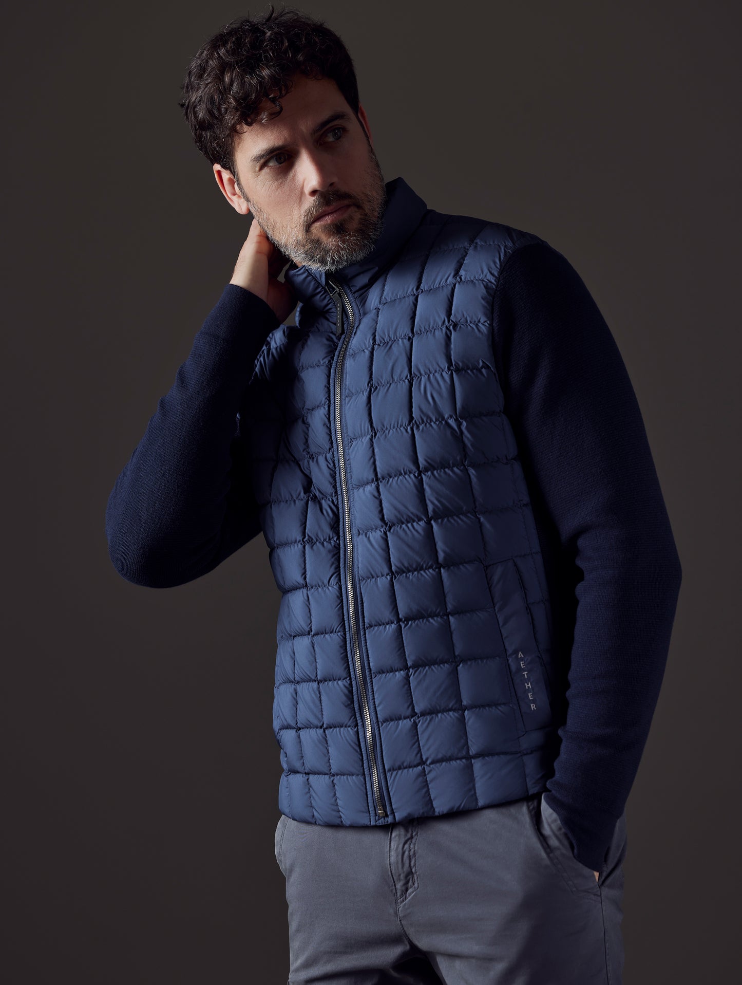 Front 3/4 body view of man wearing Phase Full-Zip in Total Eclipse dark blue from AETHER Apparel.
