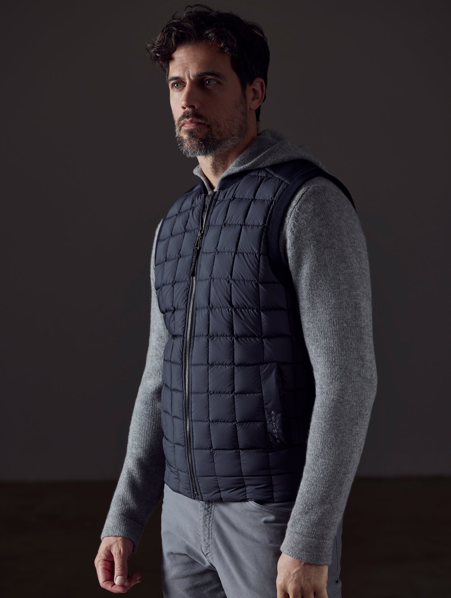 Front 3/4 body view of man wearing Phase Vest in Onyx Black from AETHER Apparel.
