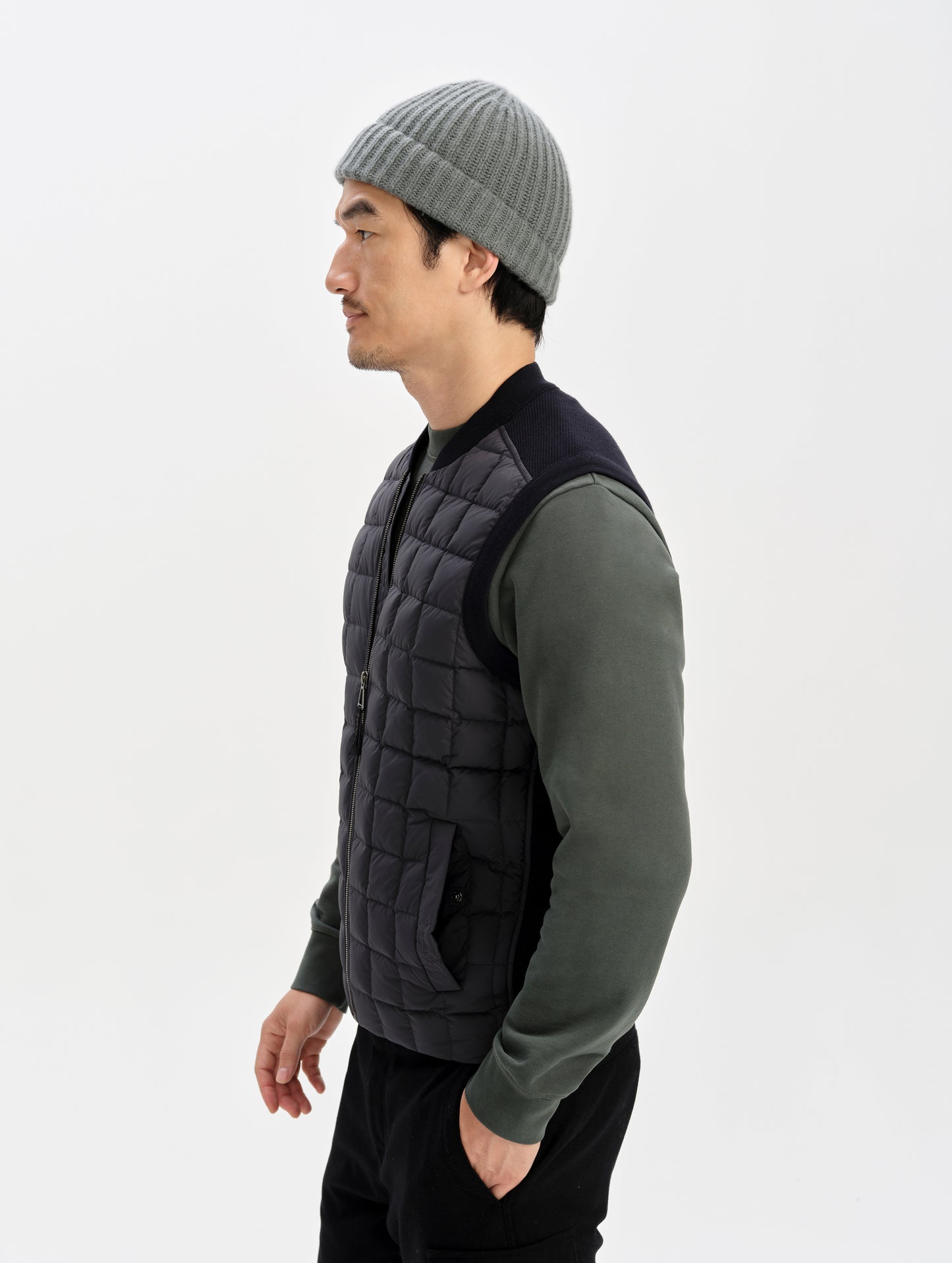 Side profile upper-body view of man wearing the M Phase Vest in Onyx Black from AETHER Apparel.