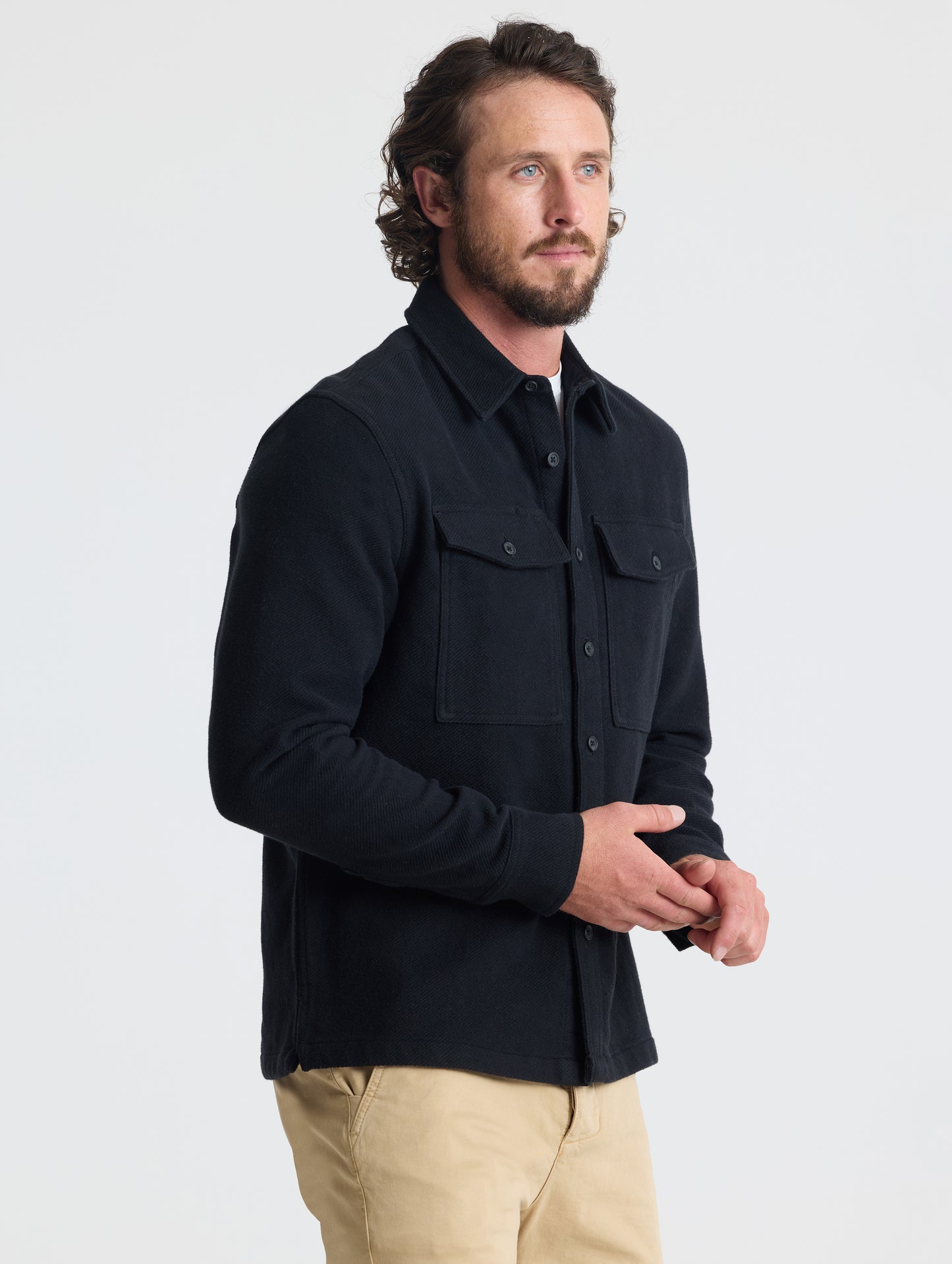 Front, angled upper-body view of man wearing Pioneer Heavyweight Button-Down in Onyx Black from AETHER Apparel.