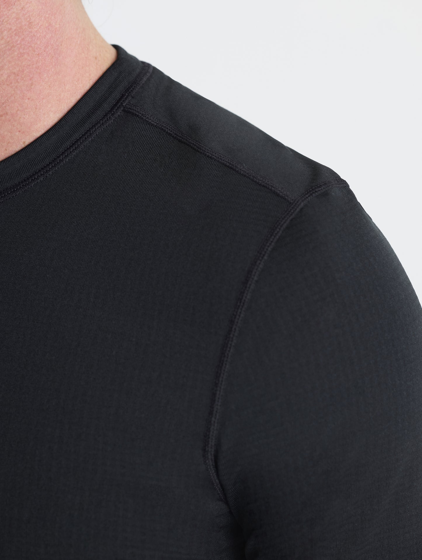 Closeup detailed view of the shoulder seams on the Polar Base Layer Crew in Onyx Black from AETHER Apparel.