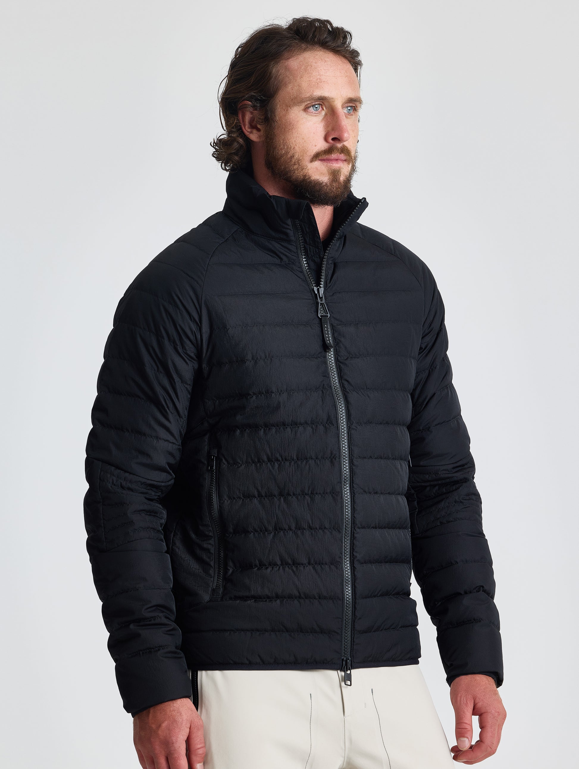 Front view of man wearing Prospect Packable Down Jacket in Onyx Black from AETHER Apparel.