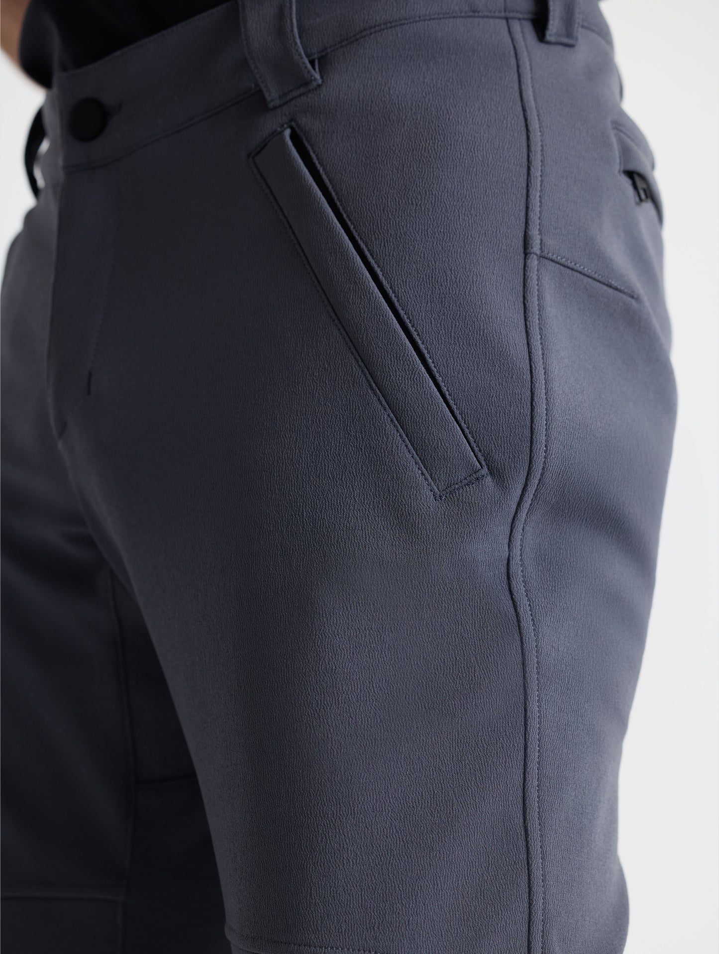 Closeup detailed view of one of the angled single welt zippered hand pockets on the Ramble Pant 3.0 in Graphite from AETHER Apparel.