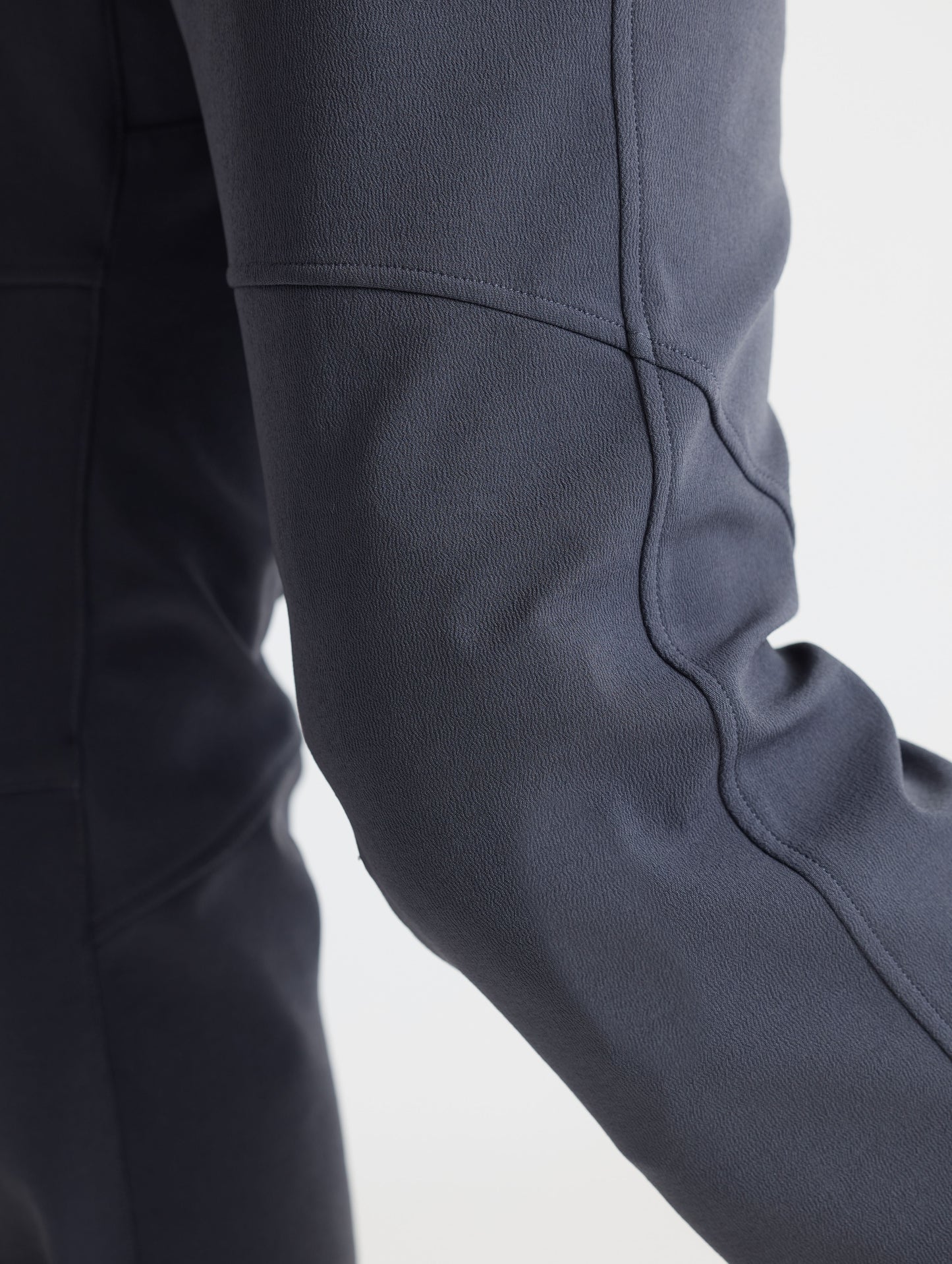 Closeup detailed view of the mobility-bolstering knee articulation darts on the Ramble Pant 3.0 in Graphite from AETHER Apparel.