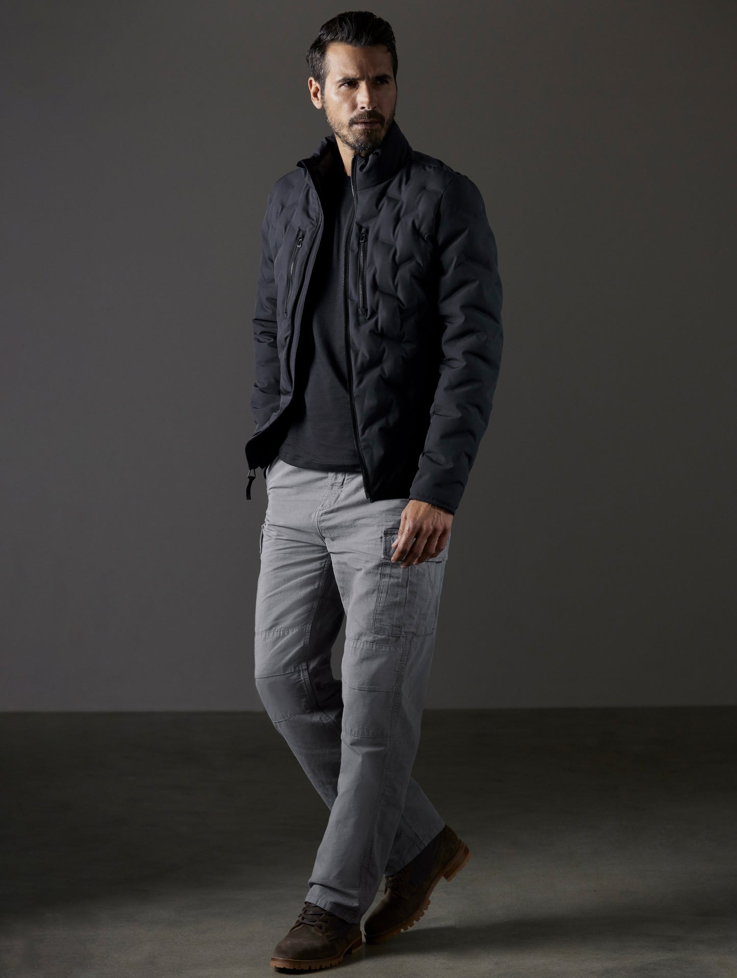 Front 3/4 full-body view of man wearing Rex Down Jacket in Onyx Black  from AETHER Apparel.