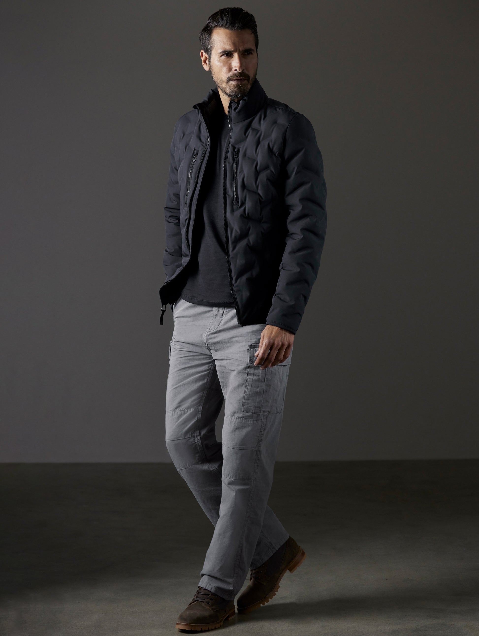 Front 3/4 full-body view of man wearing Rex Down Jacket in Onyx Black  from AETHER Apparel.