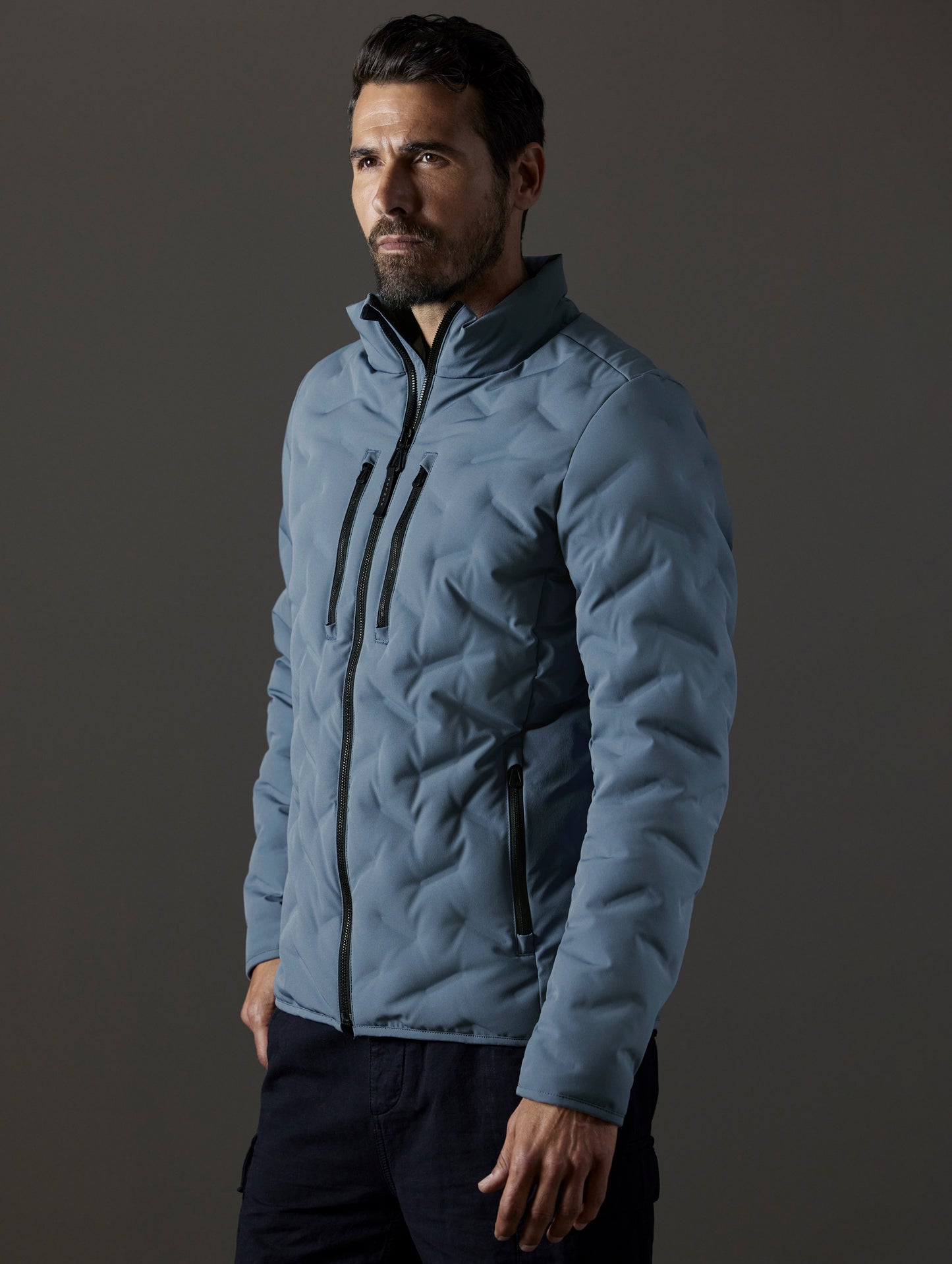 Front 3/4 body view of man wearing Rex Down Jacket in Portal Blue from AETHER Apparel.
