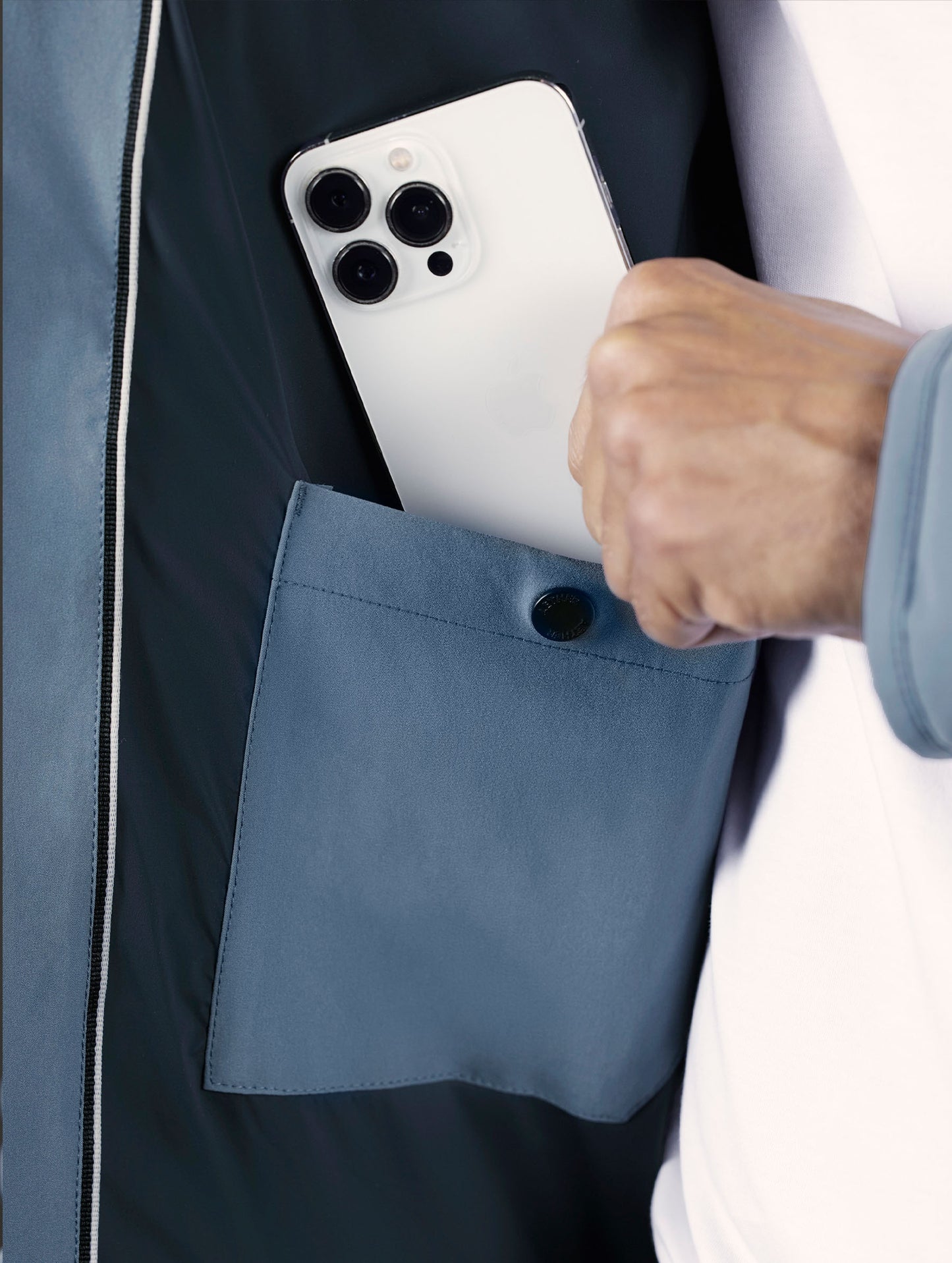 Closeup detailed view of the interior smartphone pocket on the Rex Down Jacket in Portal Blue from AETHER Apparel.