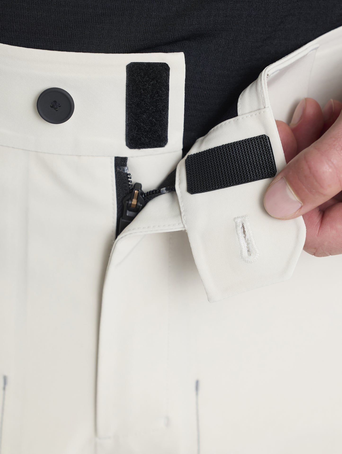Closeup detailed view of the snap and Velcro-secured waistband and zippered fly on the Ridge Insulated Snow Pant in Bone from AETHER Apparel.