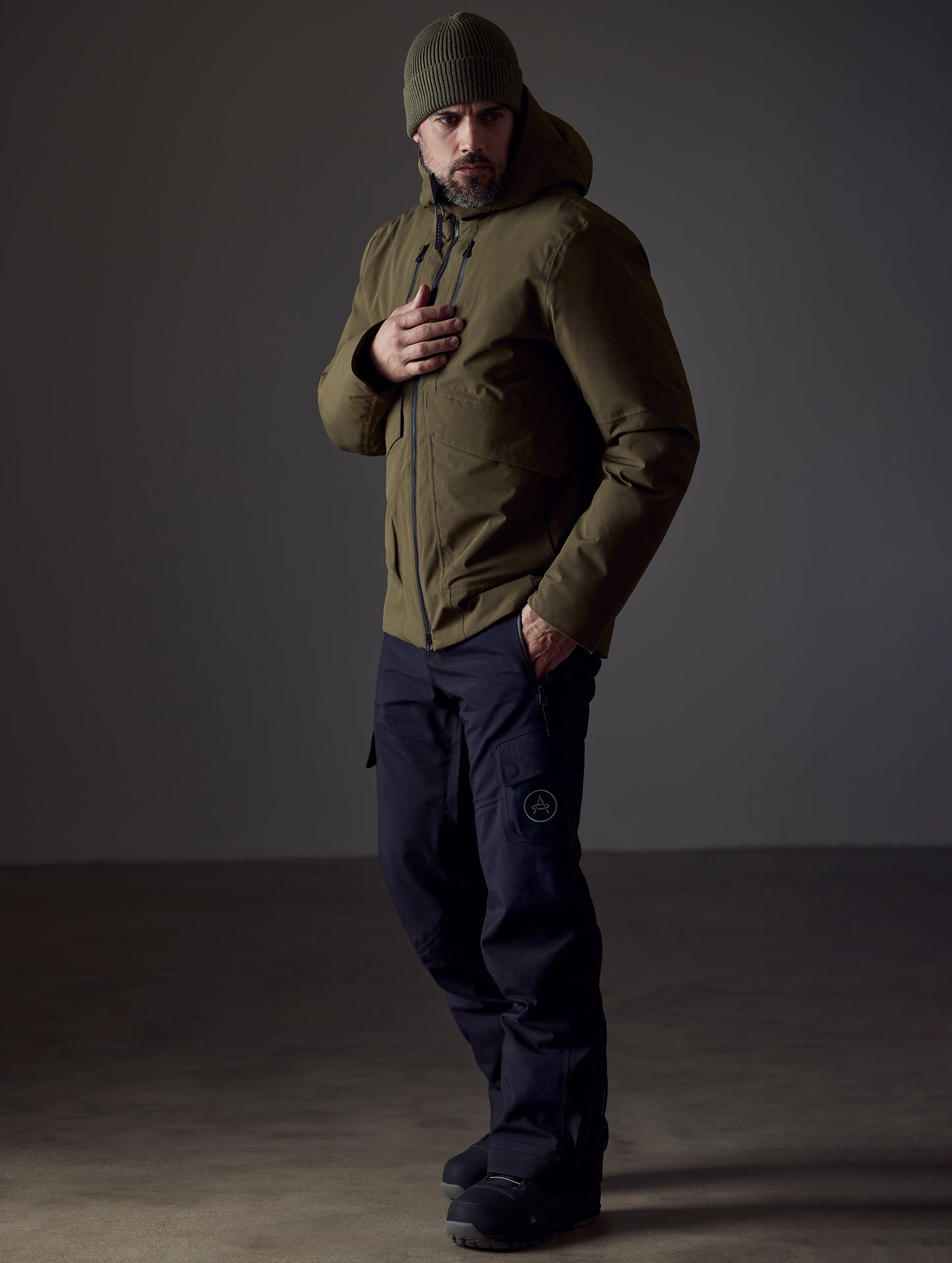 Front 3/4 full-body view of man wearing Silverton Down Jacket in Command Green from AETHER Apparel.