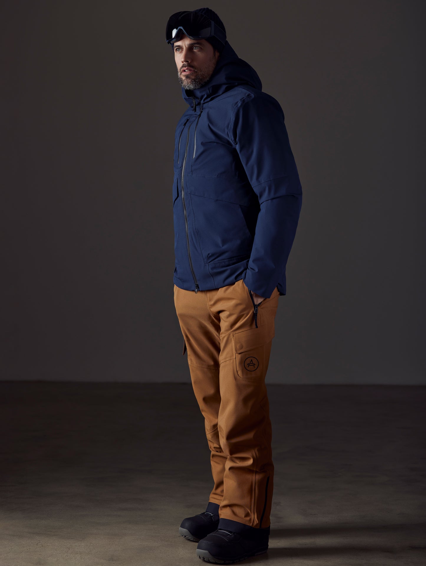 Front 3/4 full-body view of man wearing Silverton Down Jacket in Total Eclipse dark blue from AETHER Apparel.